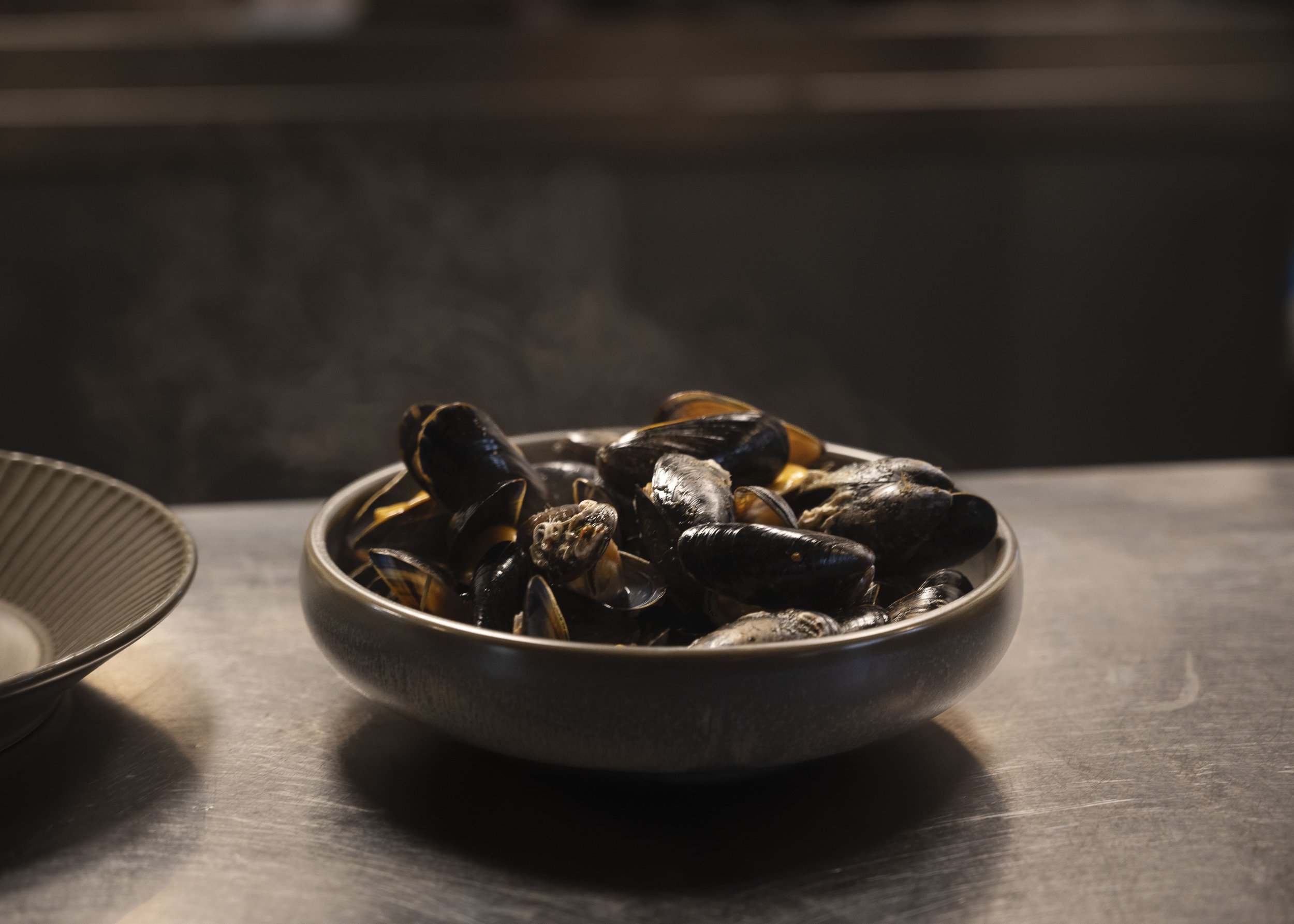 Steaming mussels in a bowl on the kitchen counter at Allmuen Bistro in Bergen.