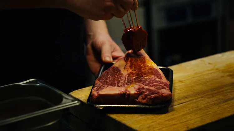 Dry-aged steak is prepared in the kitchen at Allmuen Bistro