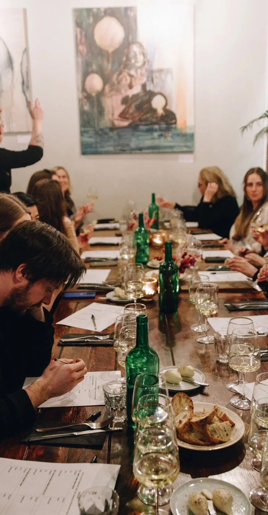 Gjester i samtale rundt langbord på Allmuen Bistro under julebord