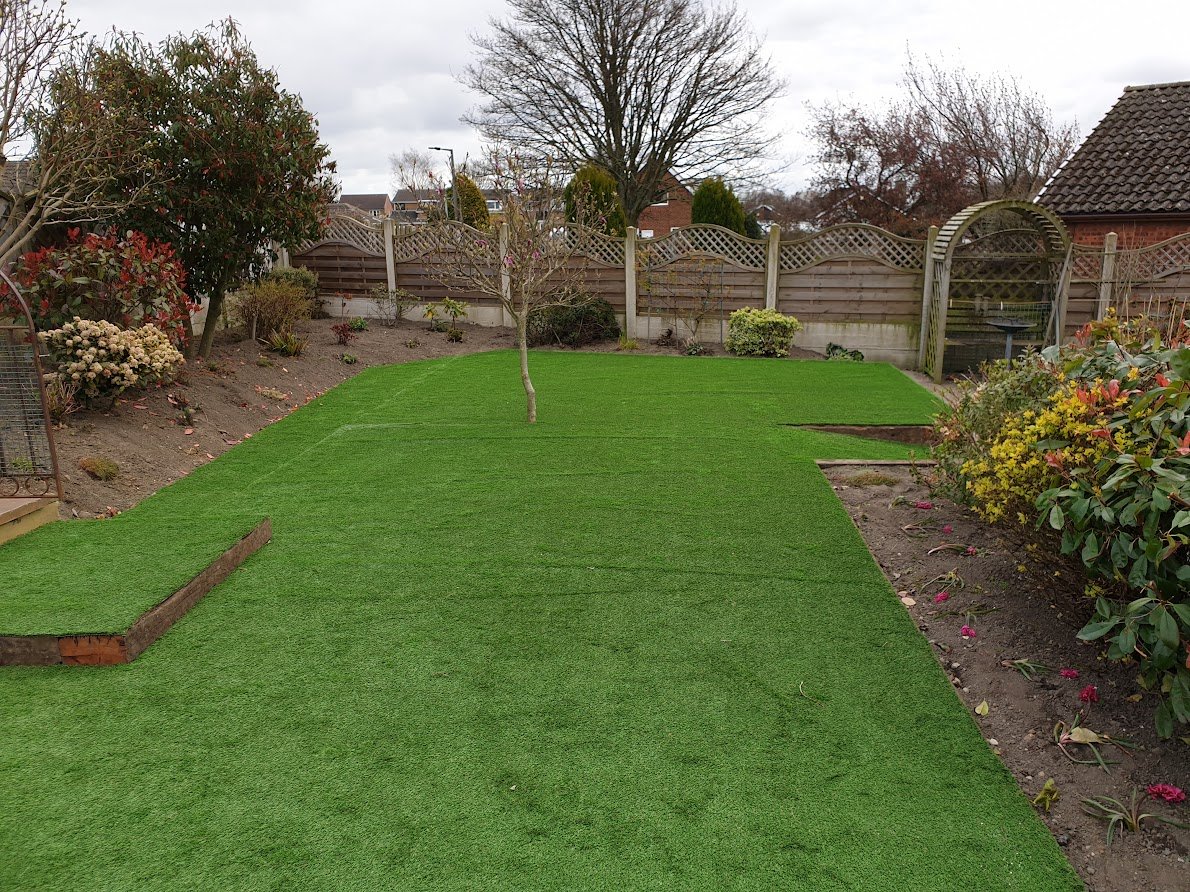 After - Ground levelled, new flower bedding, artificial grass laid