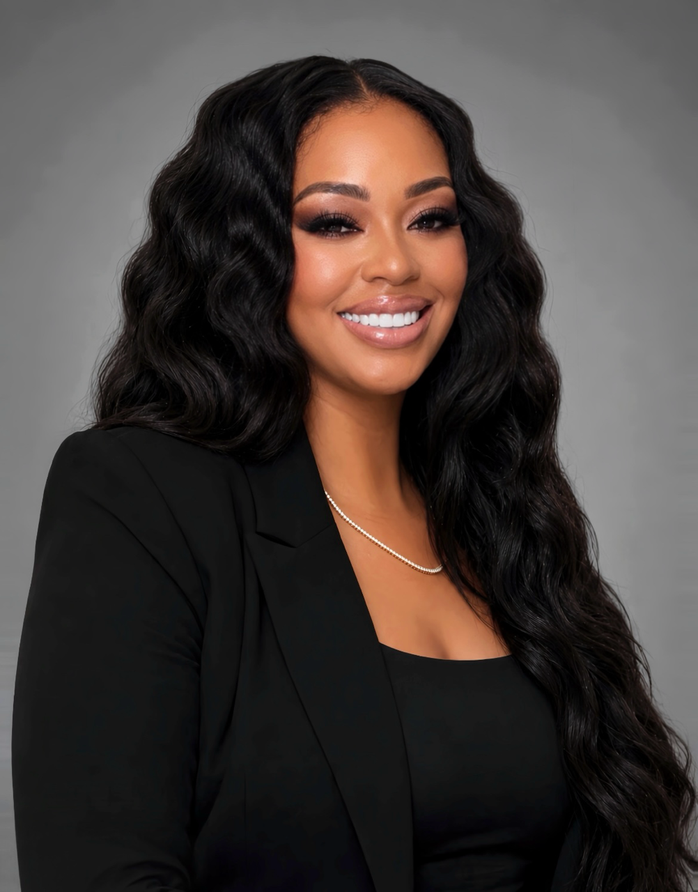 Antanisha Wiley, TURN’s Central Valley Organizer, smiling with long wavy black hair, wearing a black blazer and gold necklace.