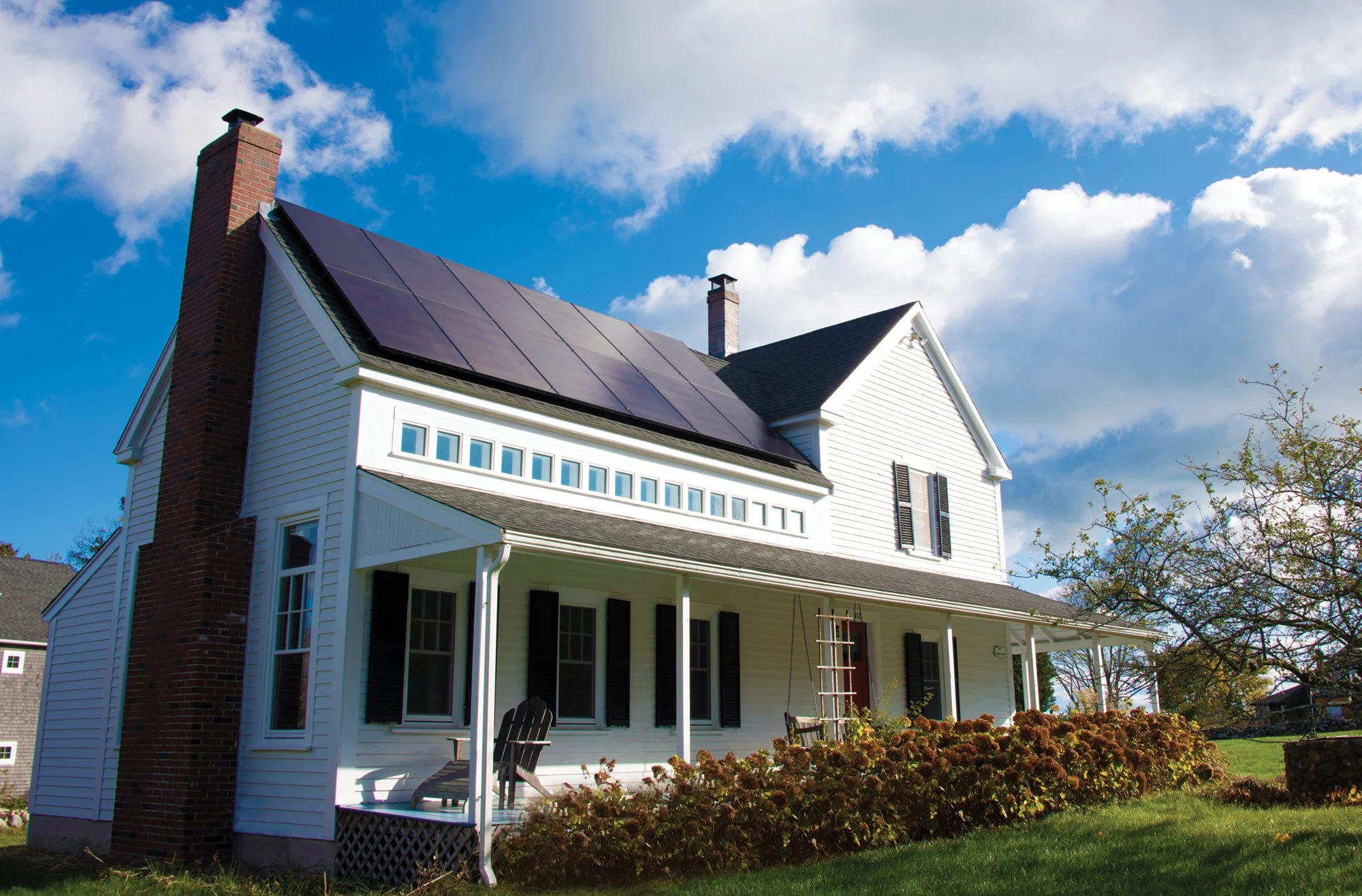 solar panels on white house; all black solar system on home with porch