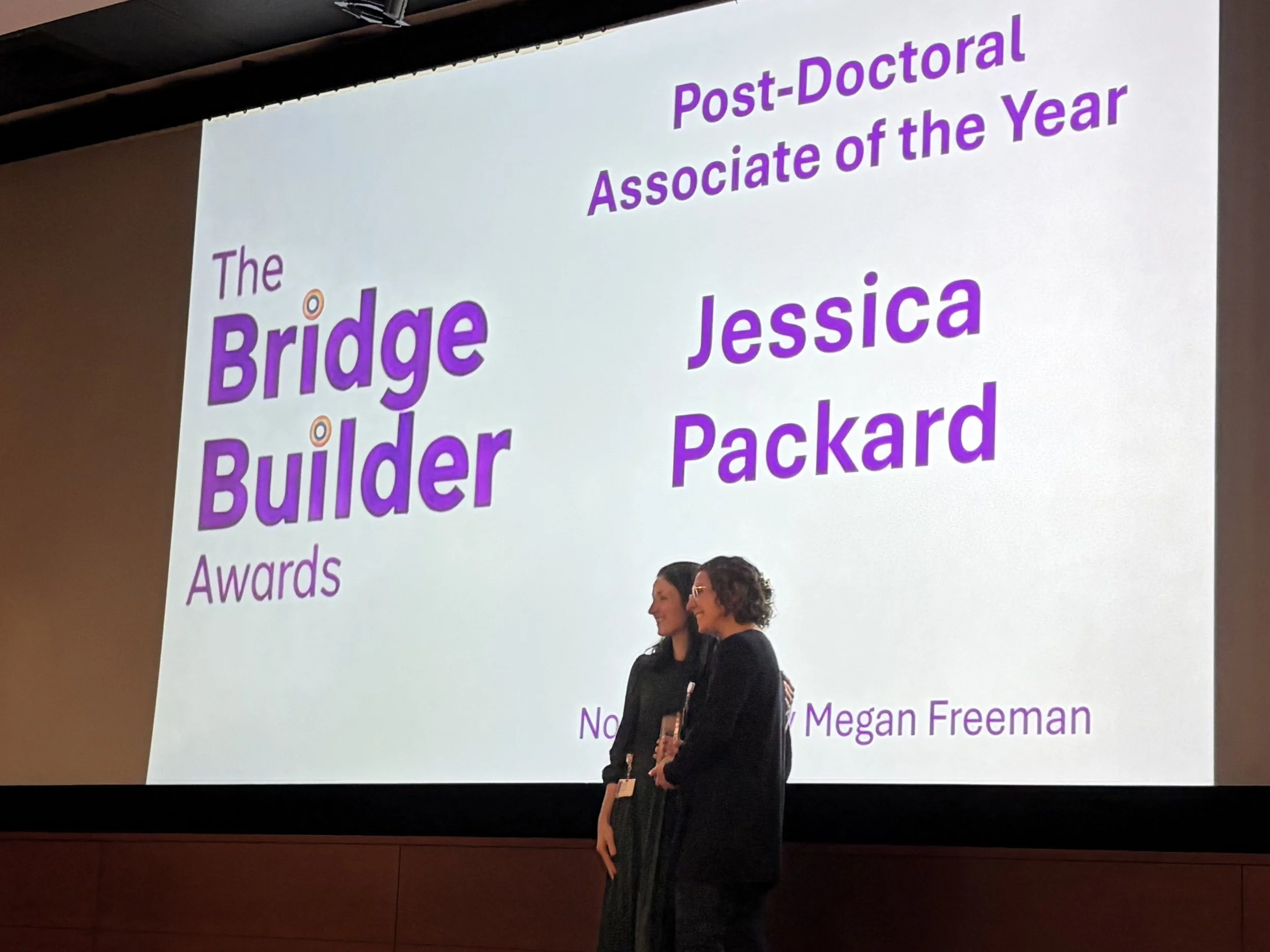 Jess wins the Bridge Builder for Post-Doctoral Associate of the Year at the Rainbow Research Symposium 2026! 🥳