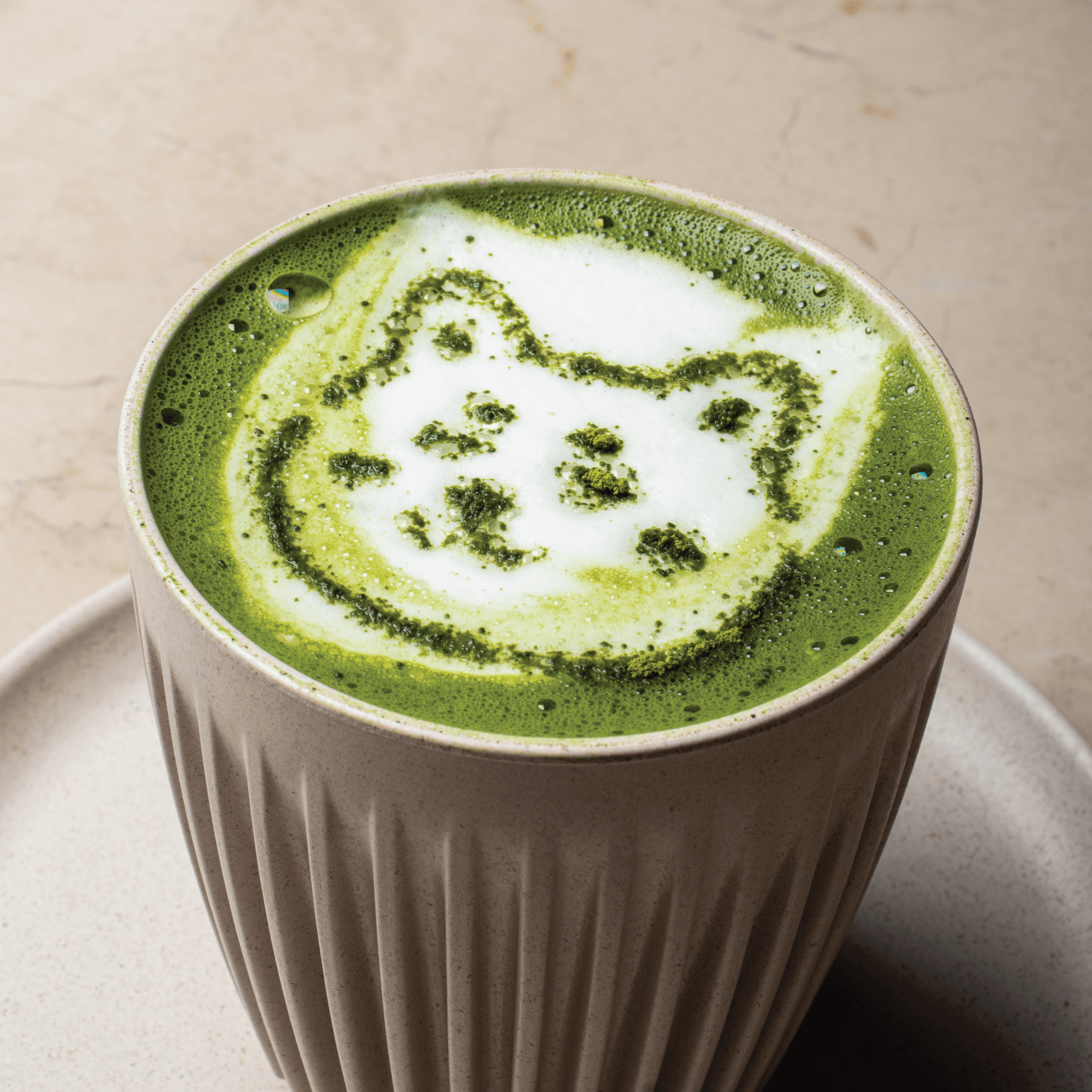 Hot matcha latte with steamed milk and bing chillin mascot foam art