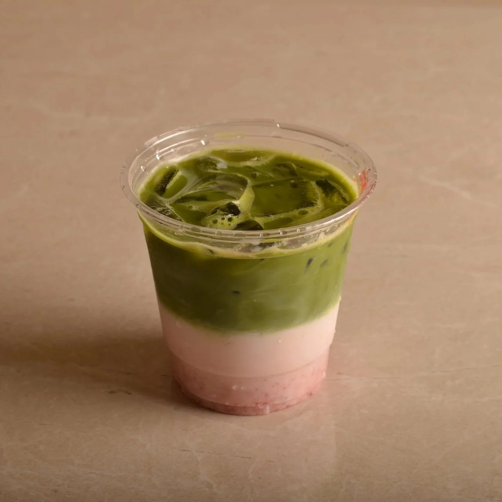 Iced strawberry matcha with strawberry purée, milk and ice