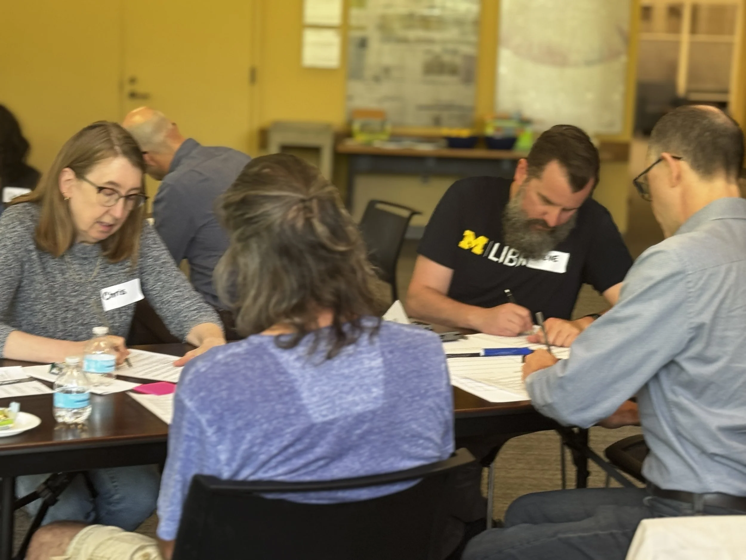 A group of people writing on a shared table