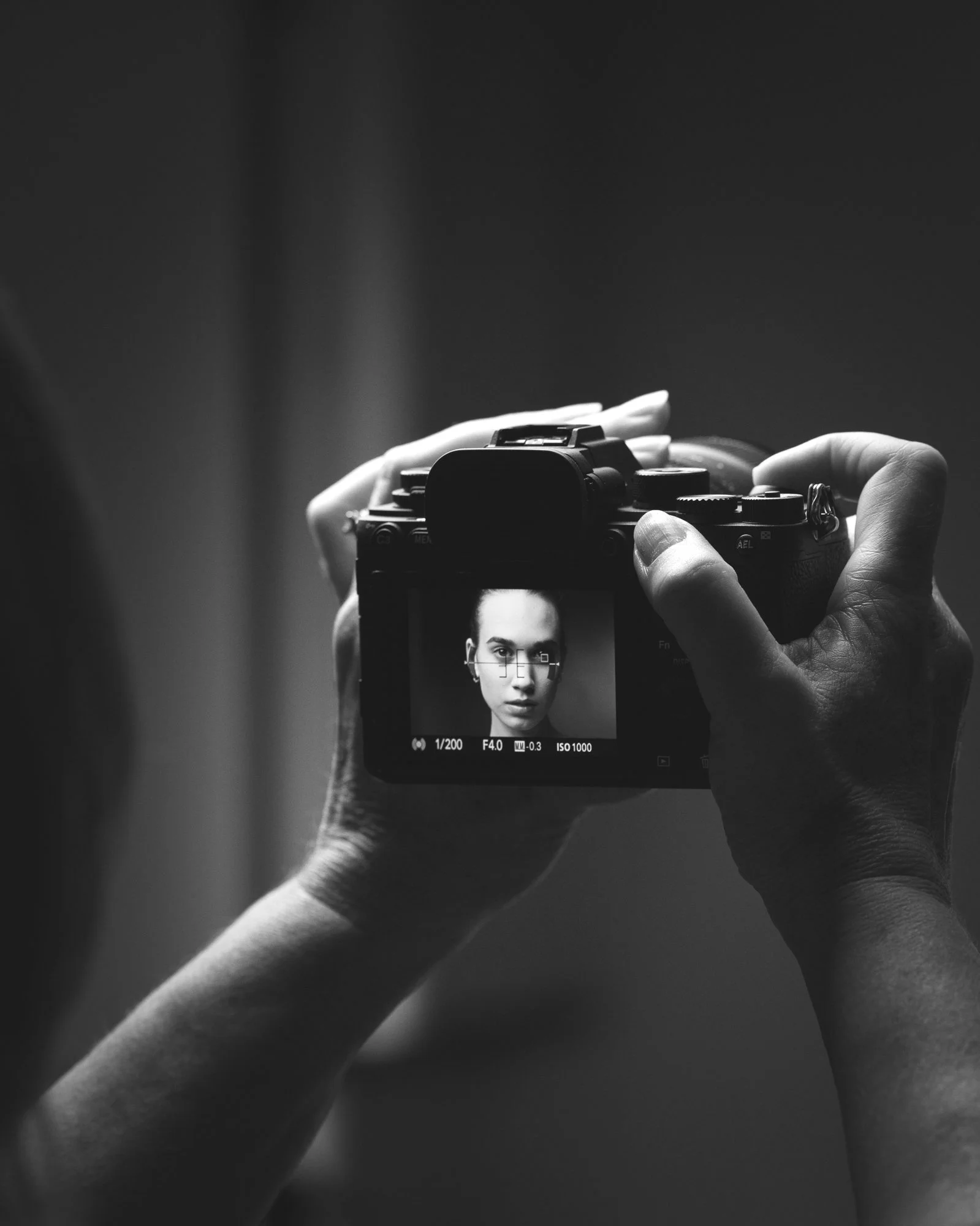A behind the scenes photo of a portrait photography workshop, showing the model on the screen of the camera.