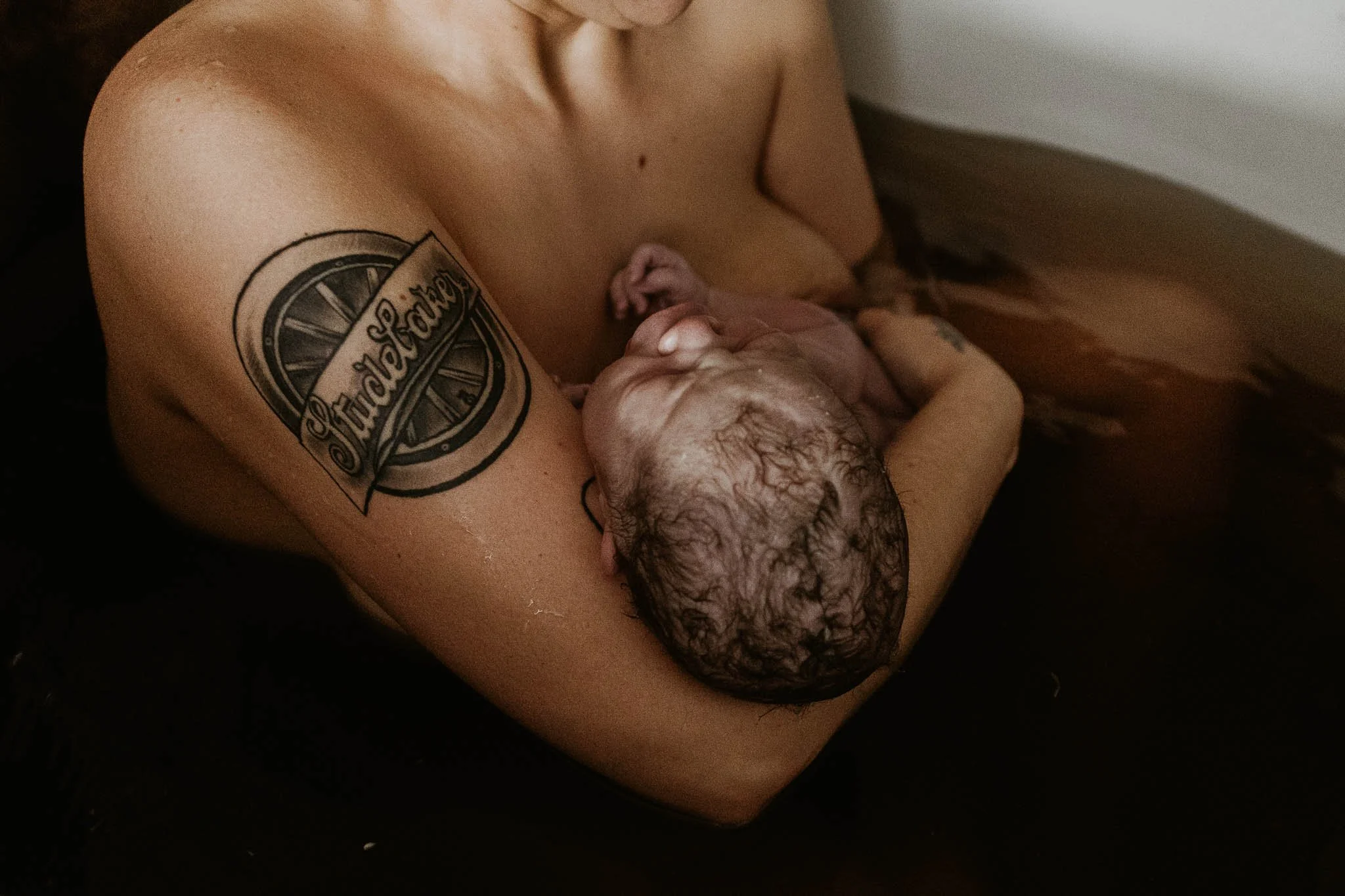 A newly birthed baby lays in his mother's arms after a long labor at the Birth Center of Bloomington Normal.