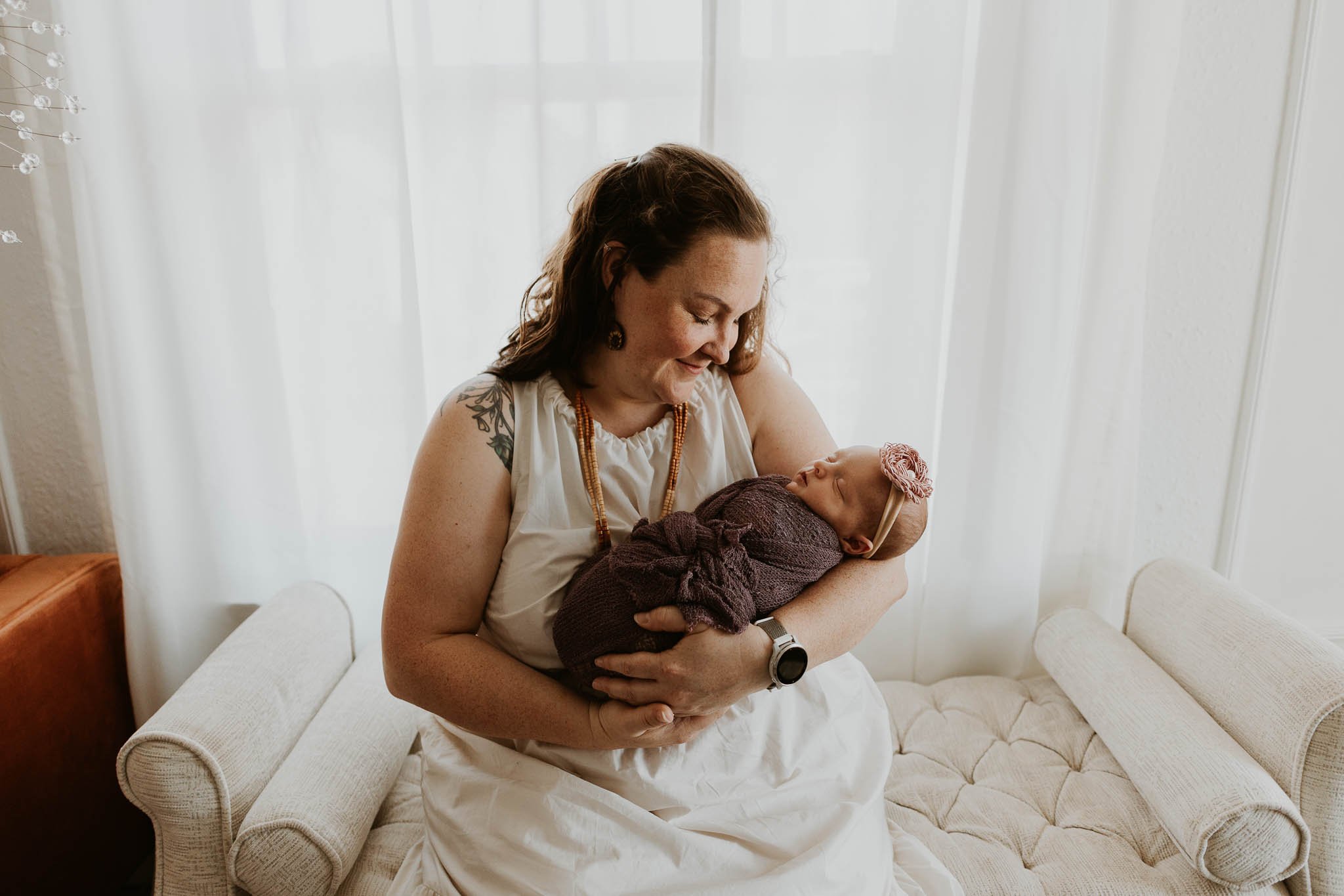 A mother admires her daughter during their newborn lifestyle photoshoot with photographer Liz Walsh.