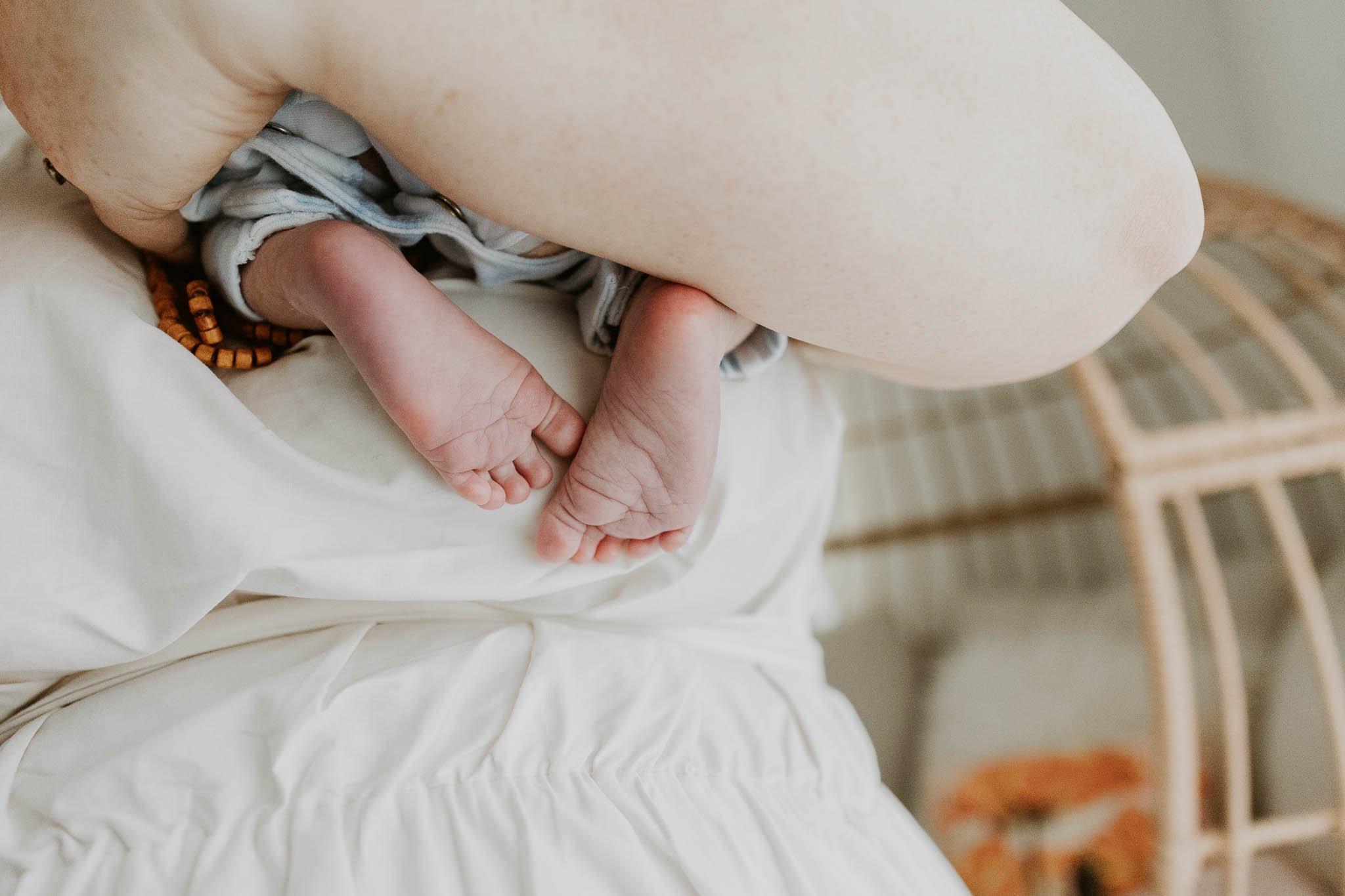 Baby toes peek out of her mother's embrace while at their newborn photography session in Bloomington, Illinois.