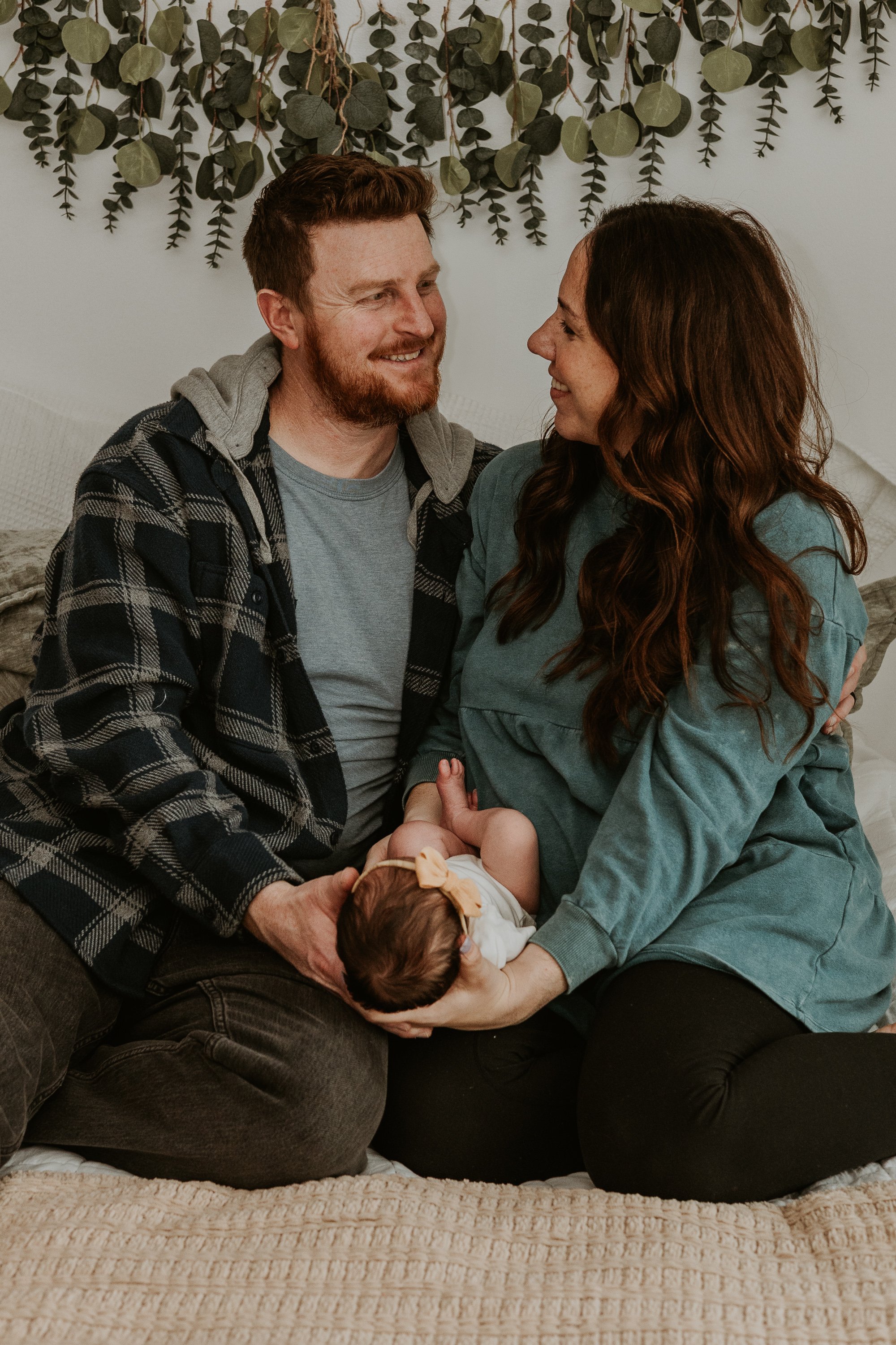A couple stare into each other's eyes, joy beaming through as they celebrate the life of their new daughter.