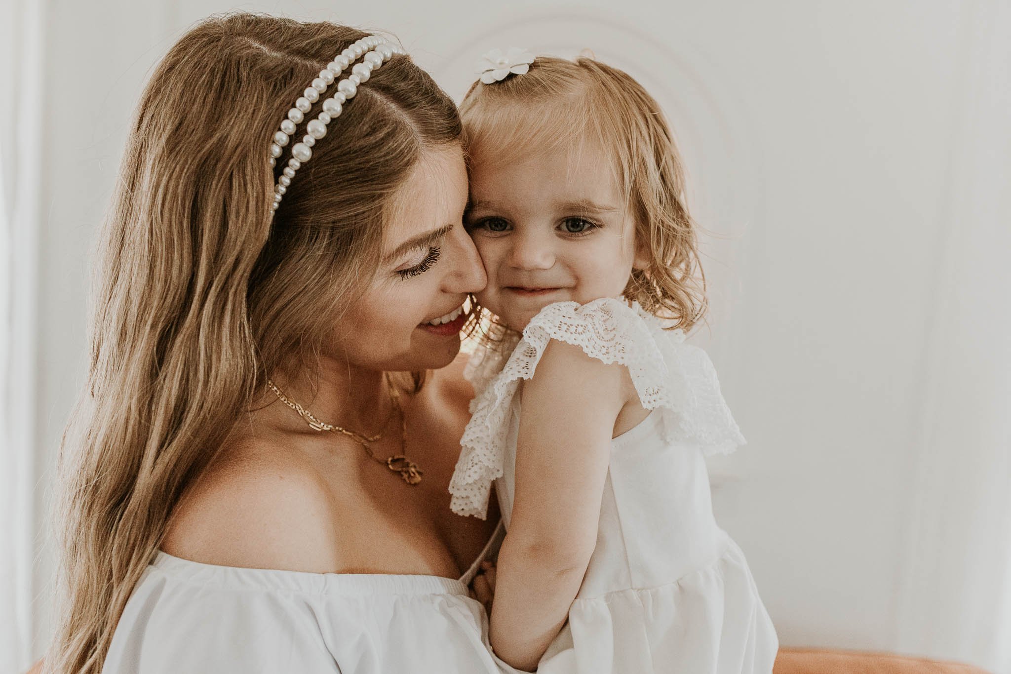 A pregnant woman and her 2 year old daughter snuggle in during a maternity photoshoot in Bloomington, Illinois.