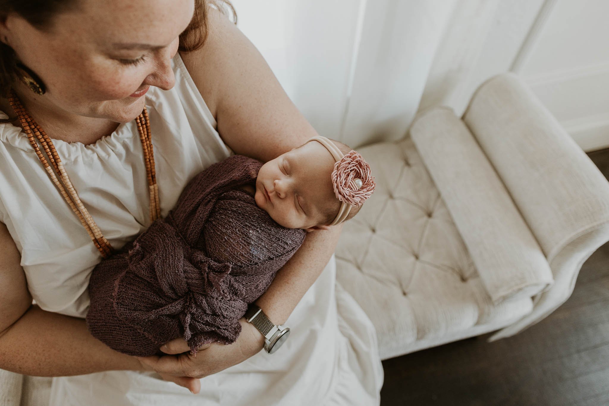 An overhead shot of a new mother with her baby during their newborn photography session.
