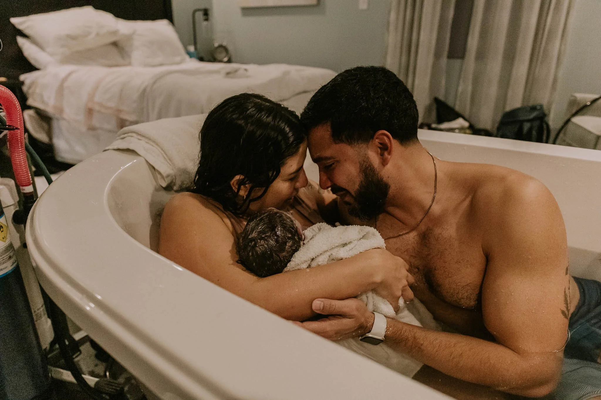 A couple touches foreheads in a tender moment of happiness after the birth of their son at the Birth Center of Bloomington Normal.
