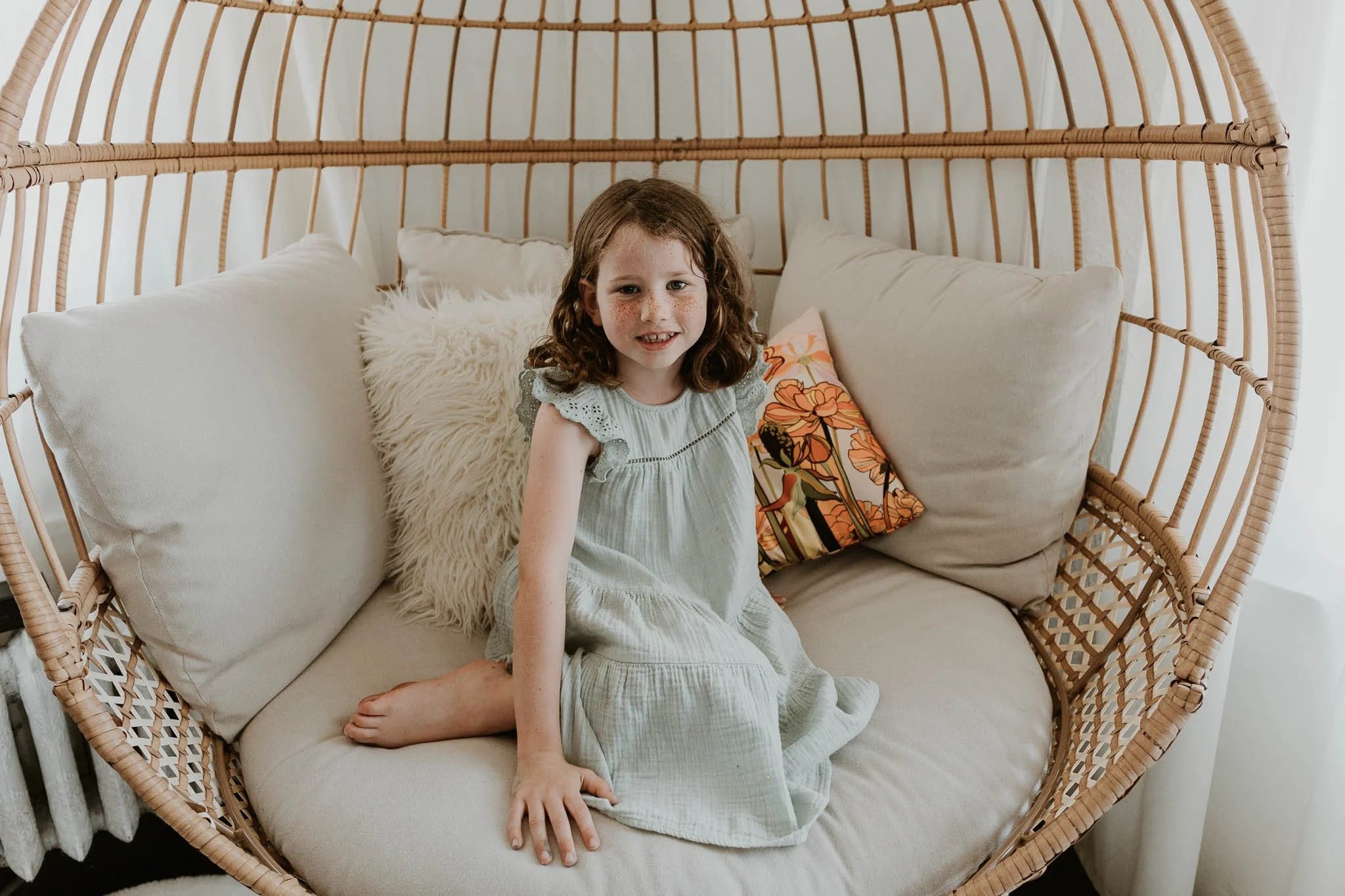 A six year old sits on a chair while Liz Walsh of Liz Walsh Doula & Photography Services takes her photo during a family photoshoot in Bloomington, Illinois.