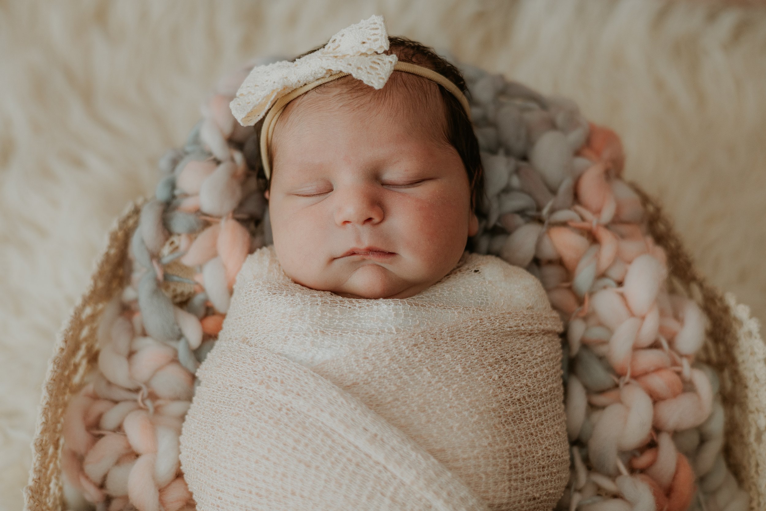 A newborn sleeps peacefully swaddled during her photoshoot in Bloomington, Illinois.