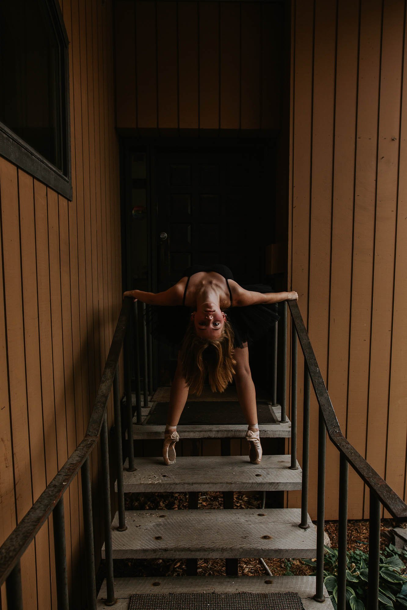 A dancer stands en pointe in a backwards bend on a staircase in Downtown Bloomington, Illinois.