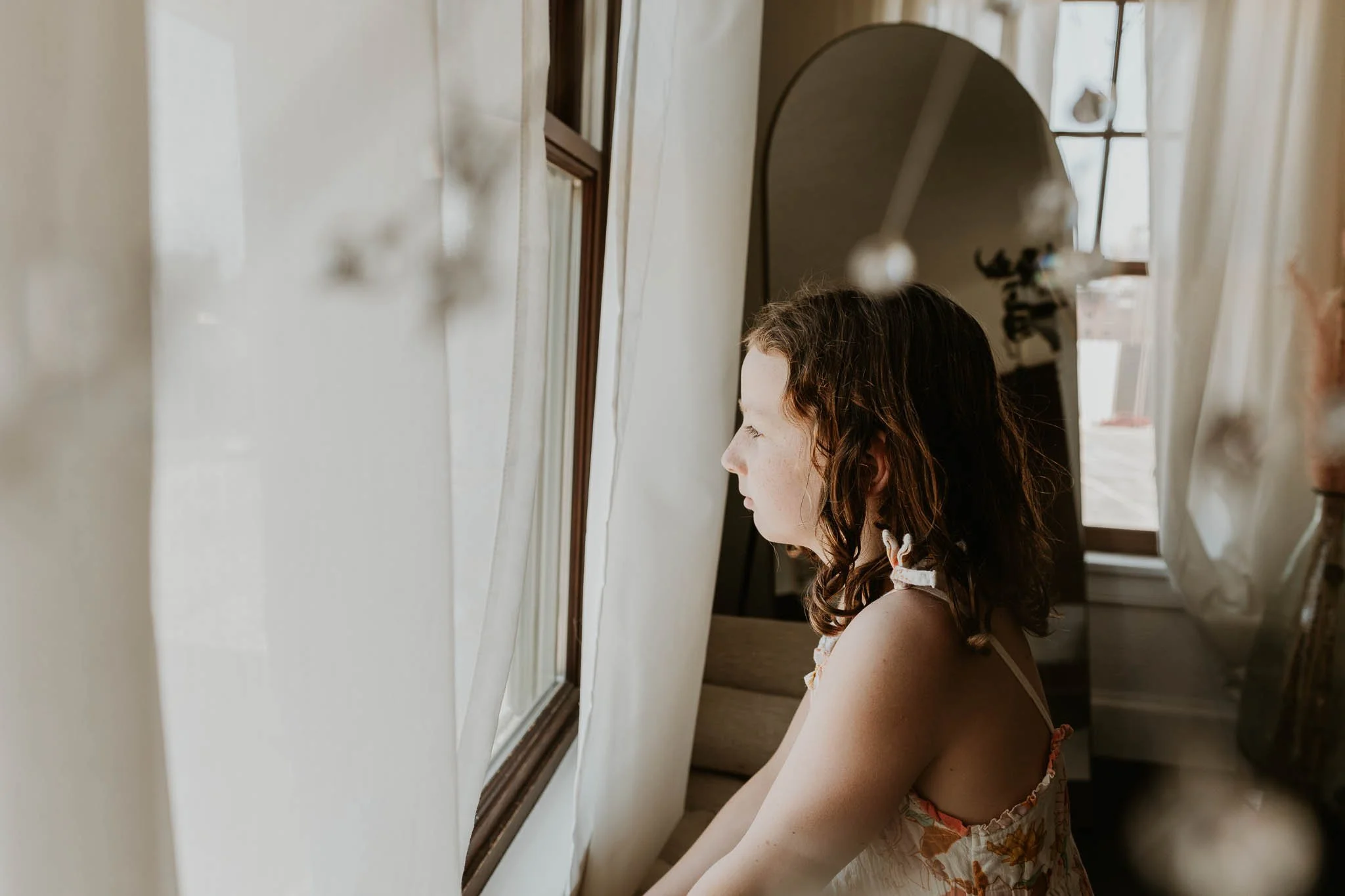 A 9 year old girl looks out a window at The 2nd Story above Girl Friday in Bloomington, Illinois.