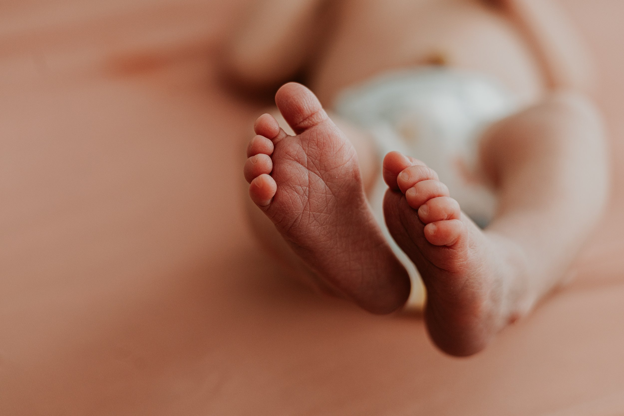 Ten tiny toes show all the creases and wrinkles in this newborn's feet.