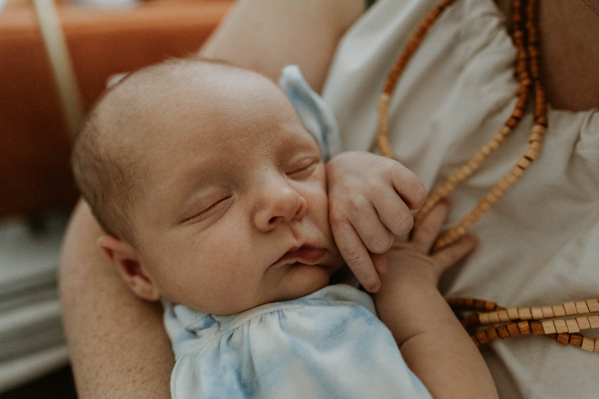 Baby's feel safest in their mother's arms, like this newborn, sleeping peacefully during her newborn photoshoot in Bloomington, Illinois with Liz Walsh