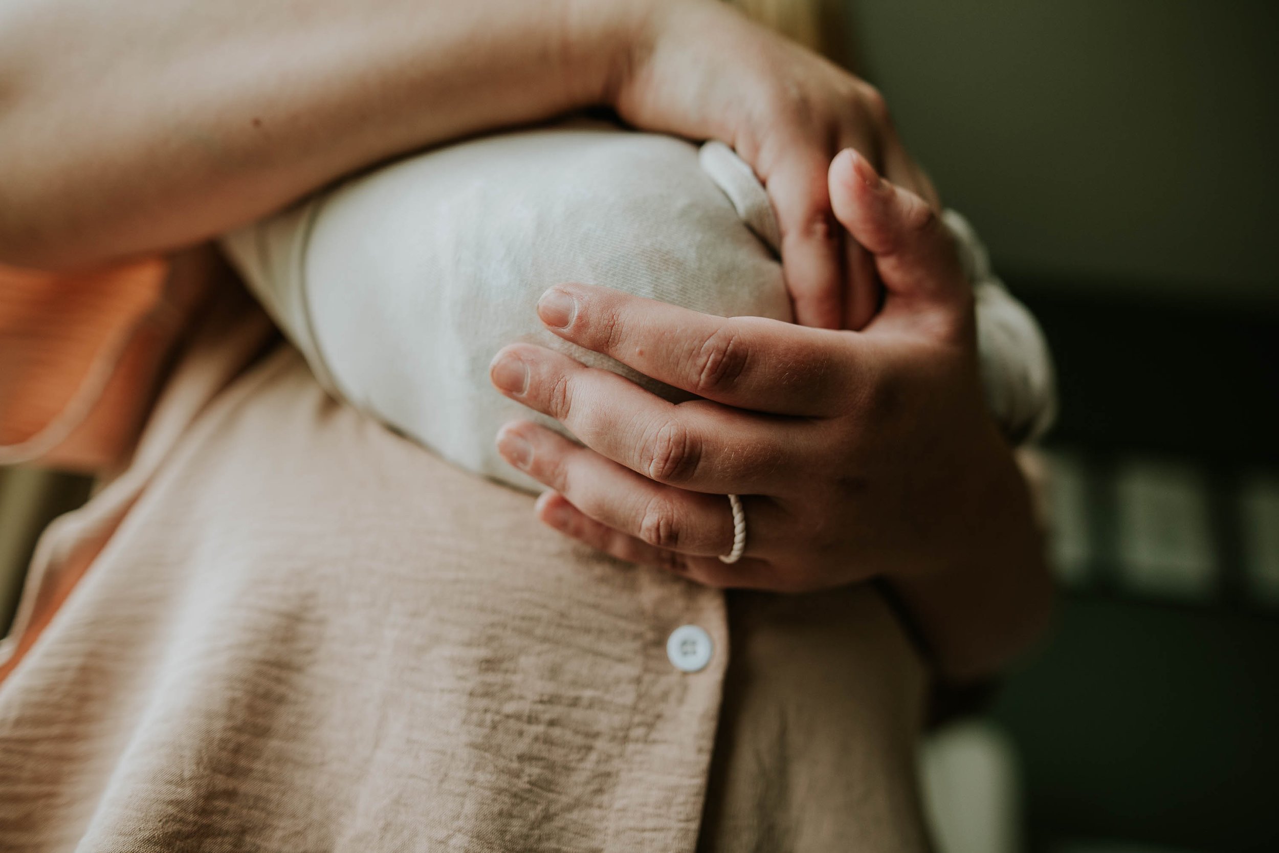 Detail photograph of mom cradling her baby.