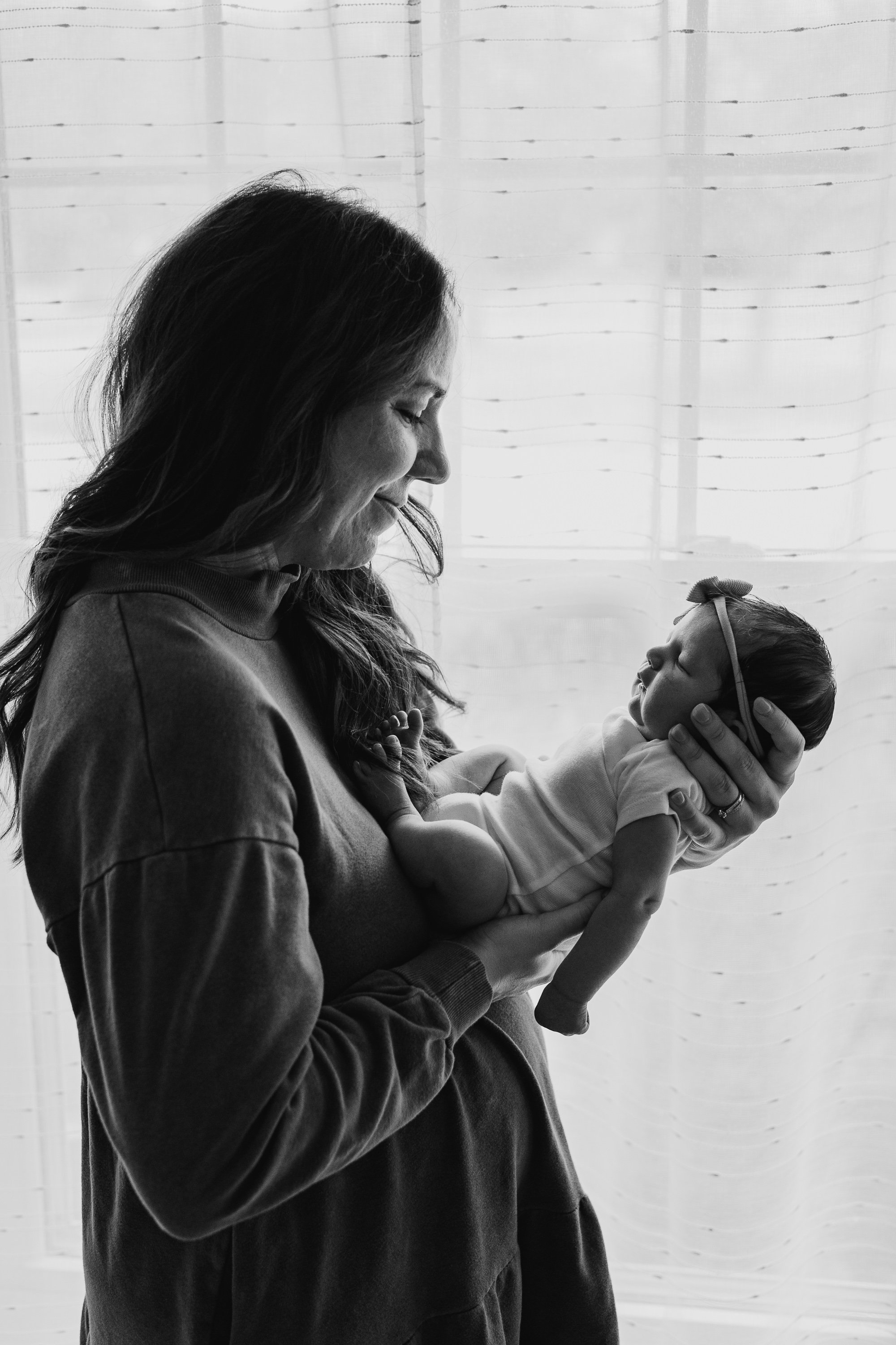 A silhouette of mom holding her infant daughter.
