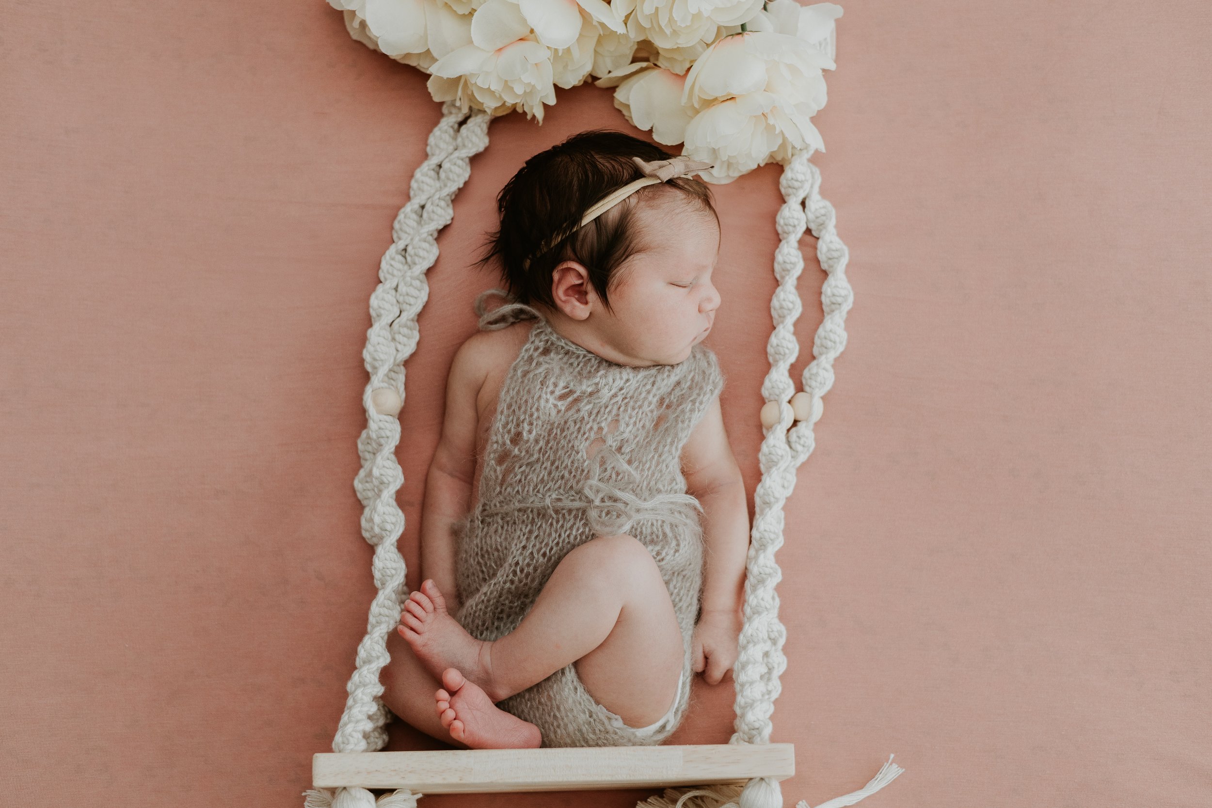 Baby girl dreaming of swaying in a tree with this swing prop used during her newborn photoshoot.