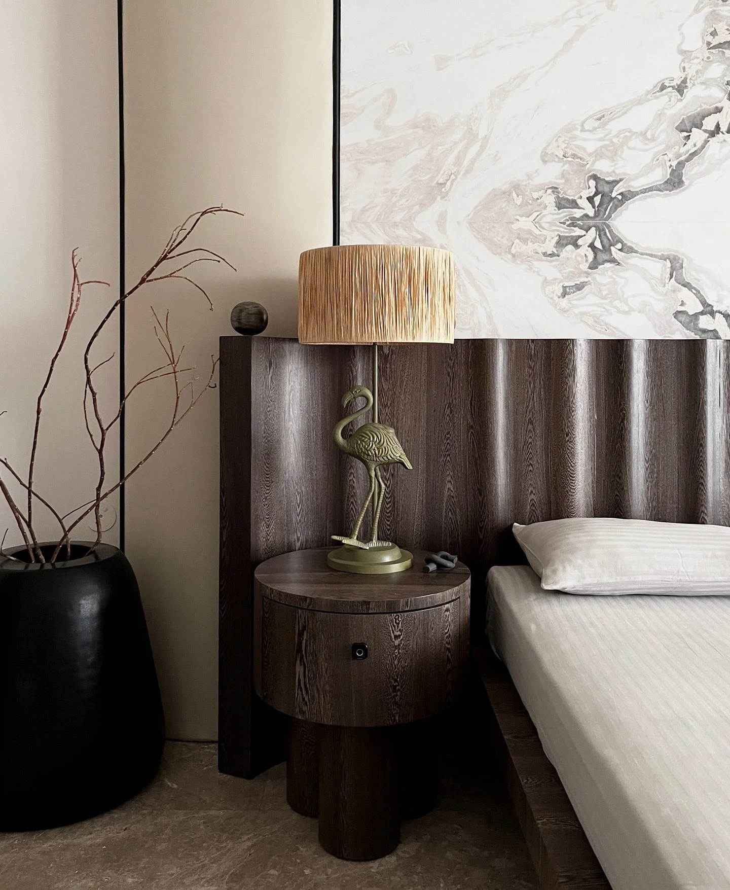 8/10 Emrabcing the essence of minimalist design with a refined touch. The dark wood bed back panel sets a grounding tone, complemented by the spherical elements for contrast. A focal point of pristine marble introduces organic flow, beige faux leathe