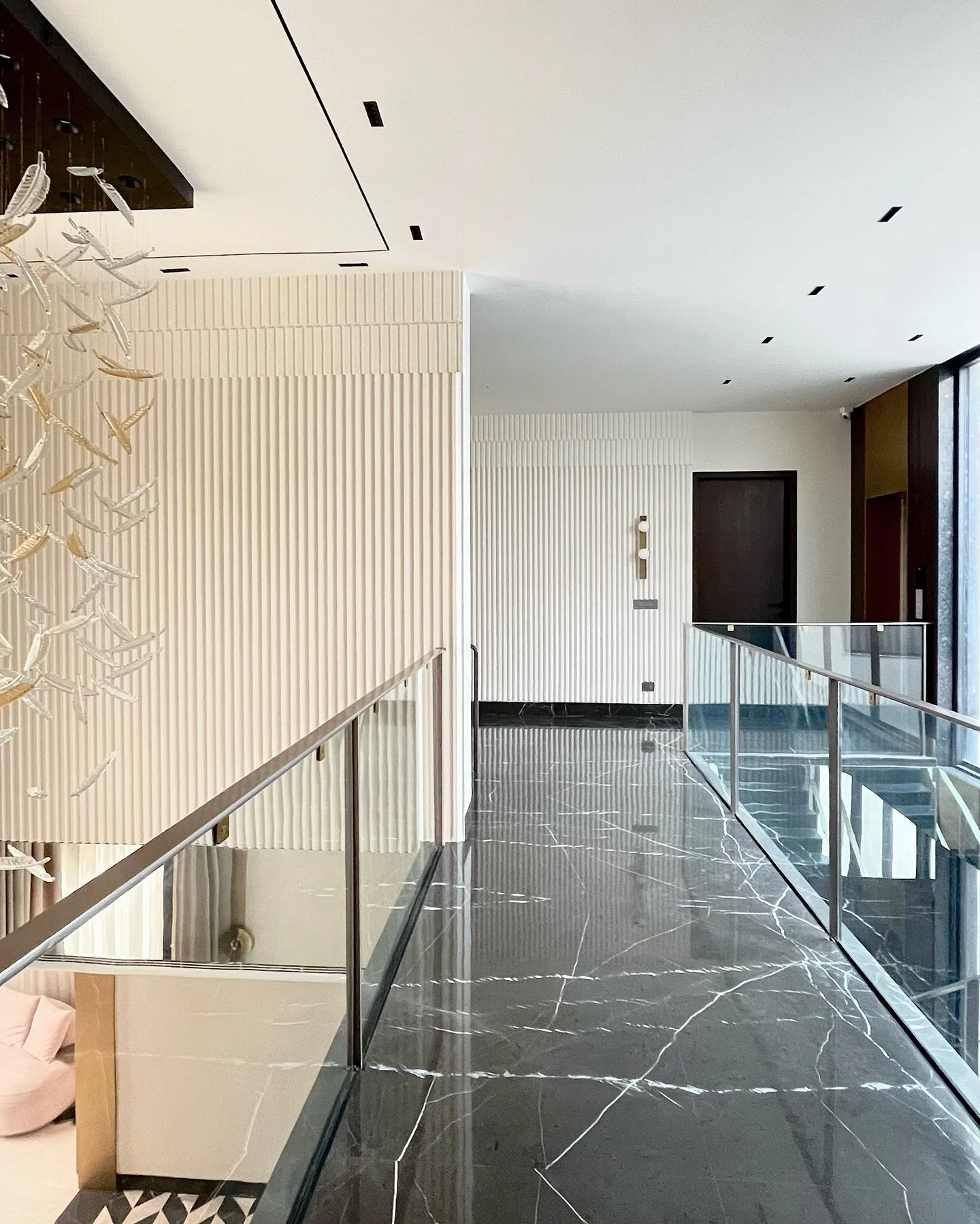9/10 The hallway exudes spaciousness, light, and minimalism with its black marble floor, feather glass chandelier and contemporary wall art.

 #ModernHome #MinimalistDesign #LuxuryInteriors#ContemporaryArt #InteriorInspiration#hallway#HomeStyling #In