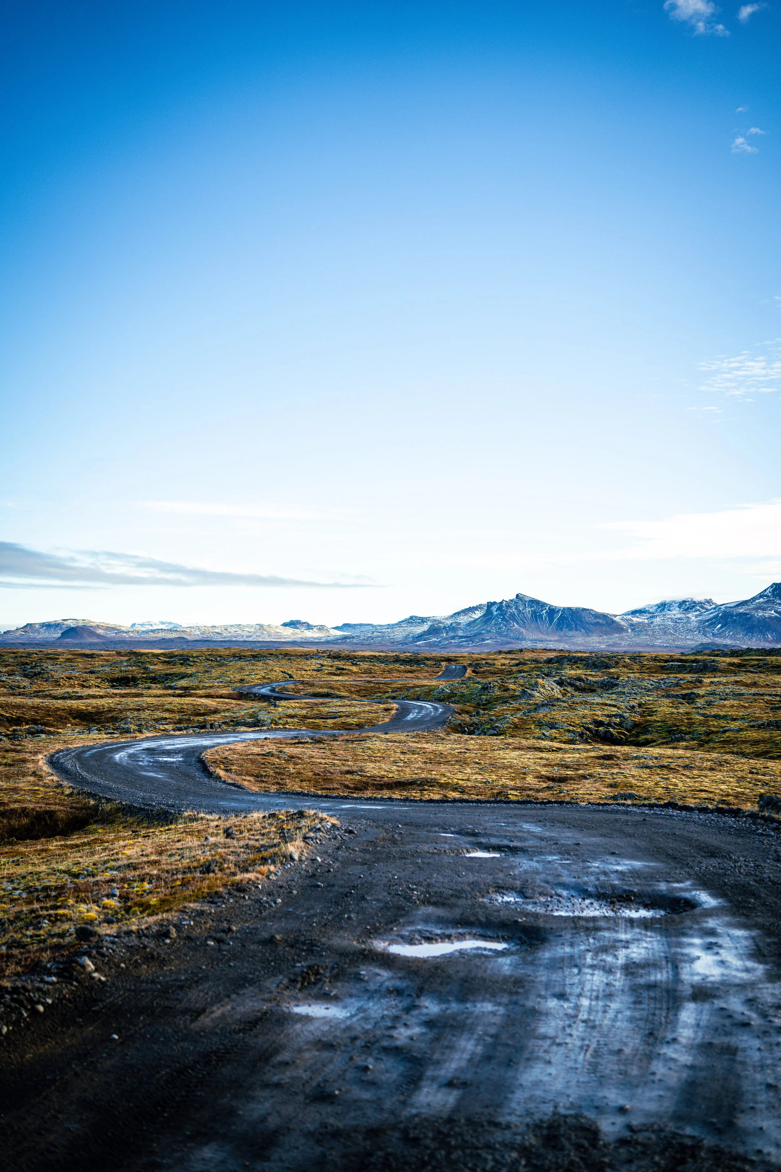 Dirty road in Iceland with mountains on the background