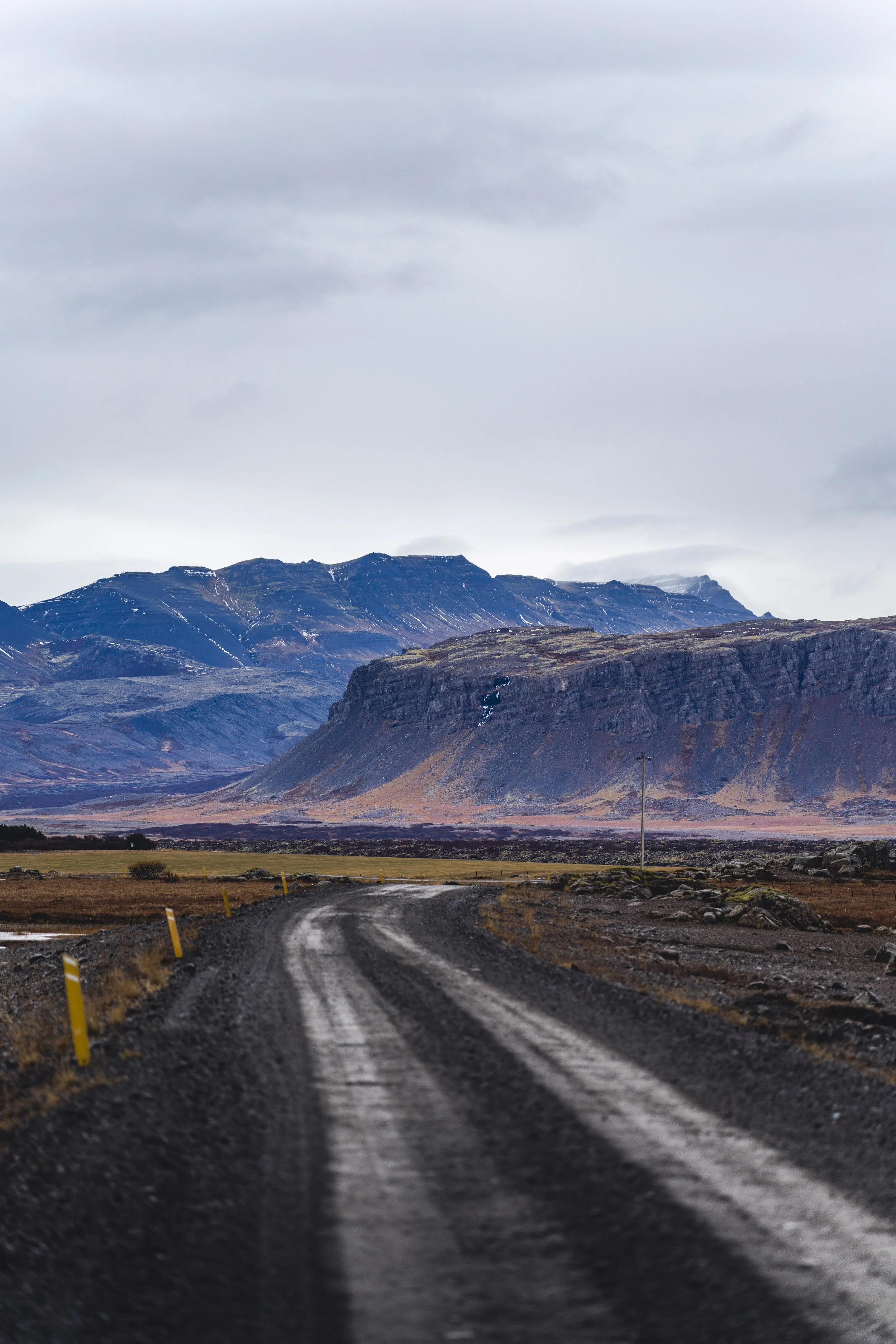 Dirty road in Iceland with mountains on the background