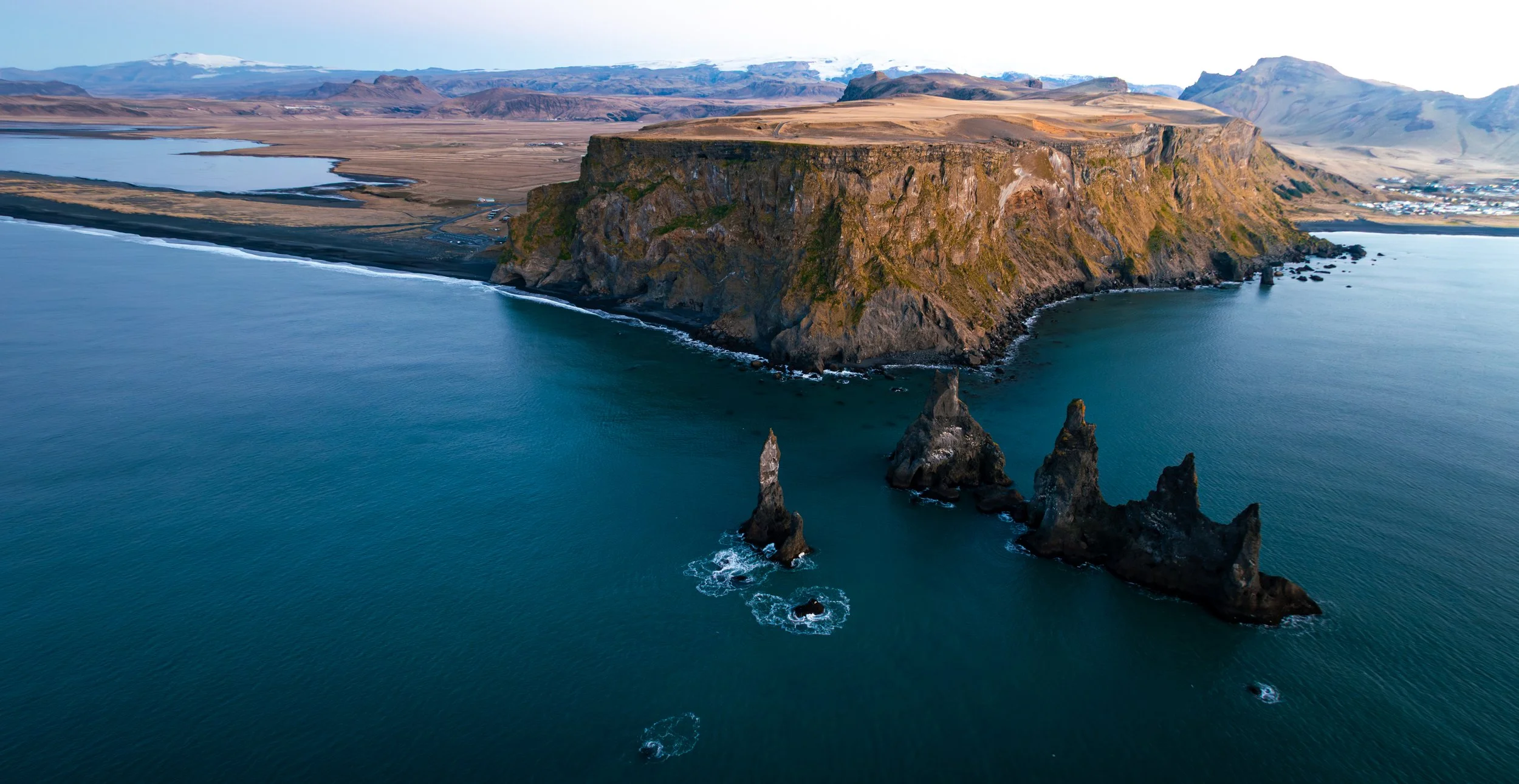 Reynisfjara black sand beach at sunrise with basalt sea stacks, southern Iceland