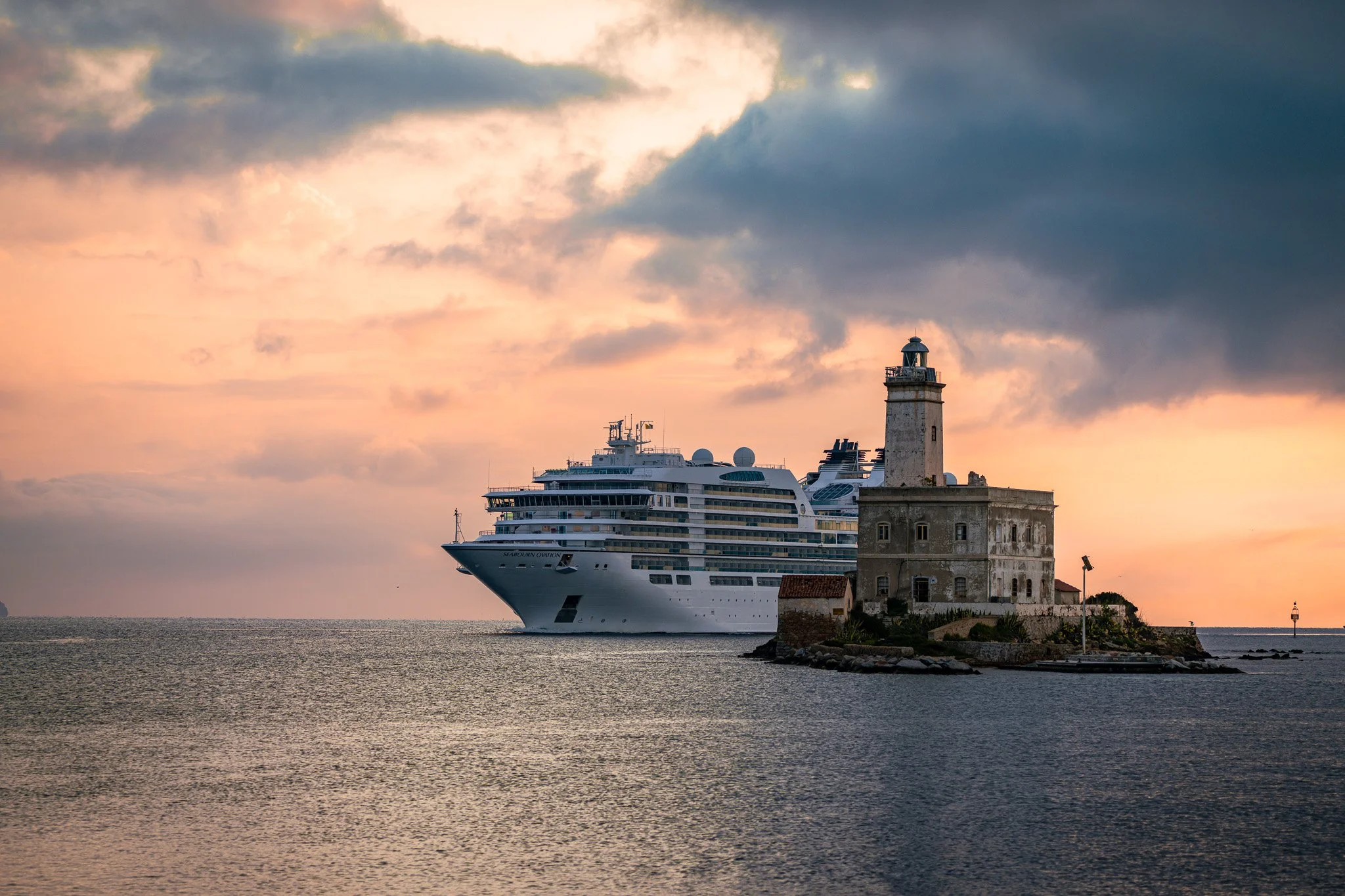 Faro di Bocca Ligthouse with cruise in the background at sunrise in Sardinia