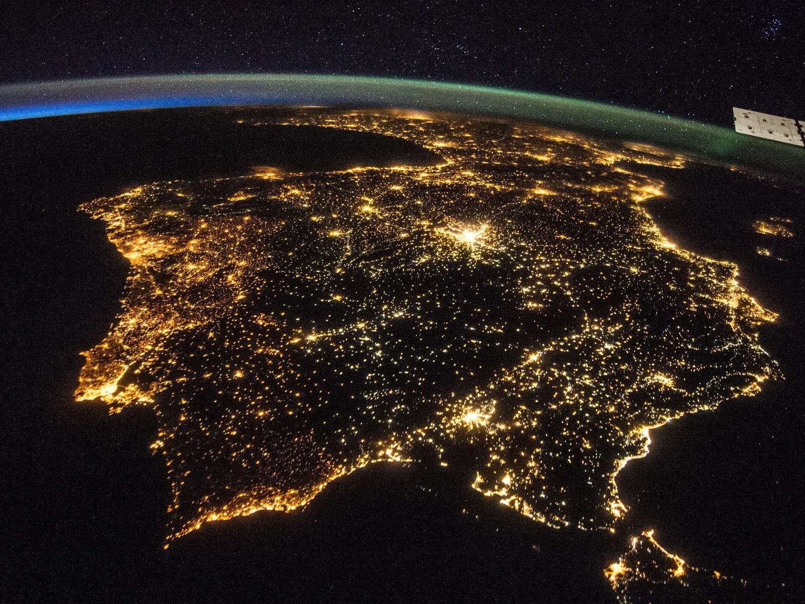 Península Ibérica à noite vista da Estação Espacial Internacional, com as luzes de Portugal e Espanha e a curvatura da Terra