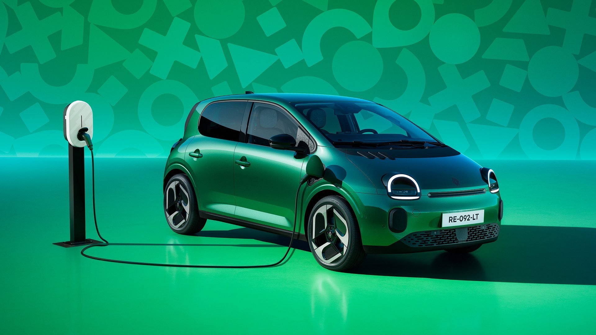 Renault Twingo E-Tech verde ligado a um carregador de parede