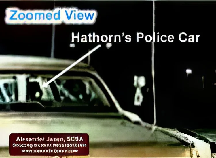 The rear of the suspect's gold Cadillac is seen. Hathorn's vehicle appears from the left.