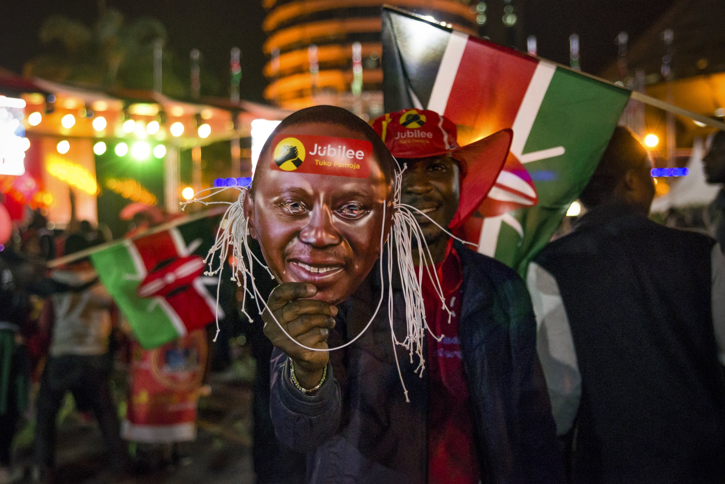  A man holds a paper mask bearing President Uhuru Kenyatta’s face at the celebration event hosted the Jubilee political Party in Nairobi, Kenya. Hundreds gathered in downtown Nairobi to celebrate Kenyatta’s second term win.  
