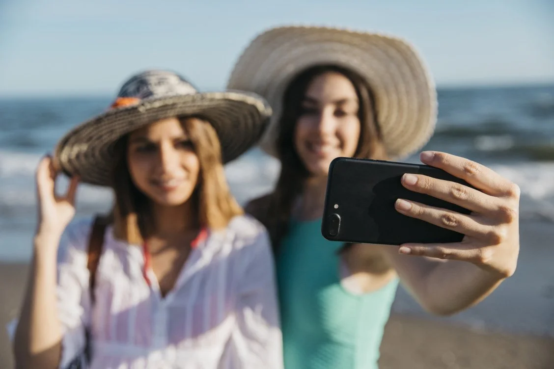 girls taking selfie at beach