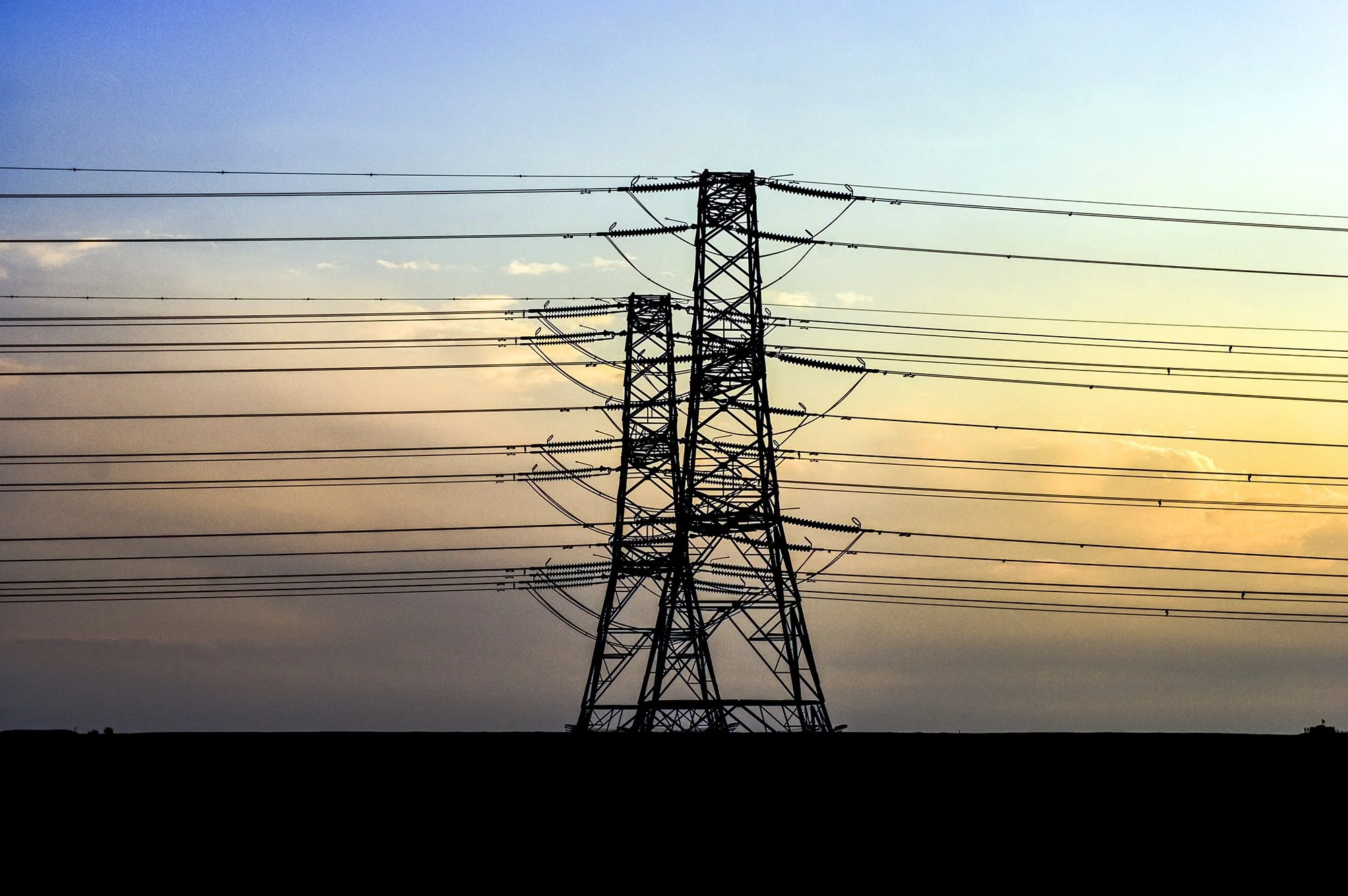 electricity pylon against setting sun