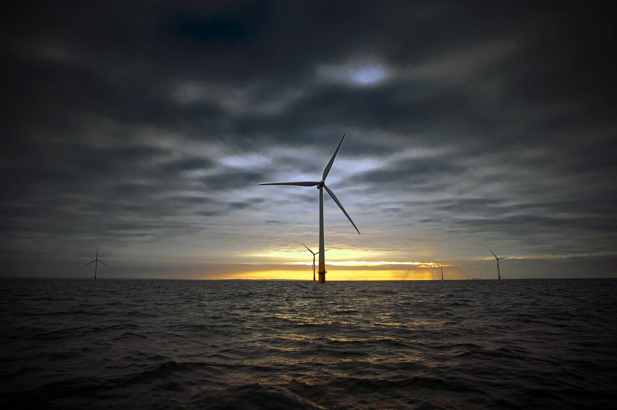  turbine on offshore wind farm at sunset 