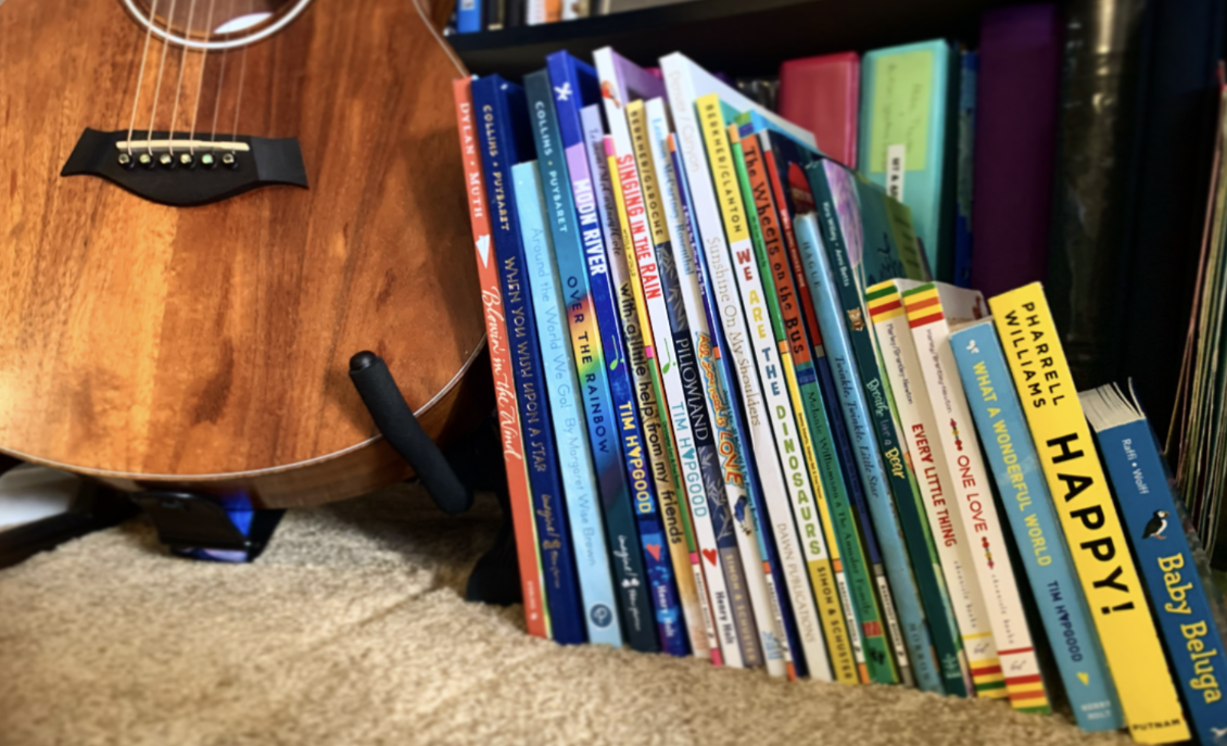 A collection of singable picture books alongside a guitar in a music therapy room at The Sonatina Center