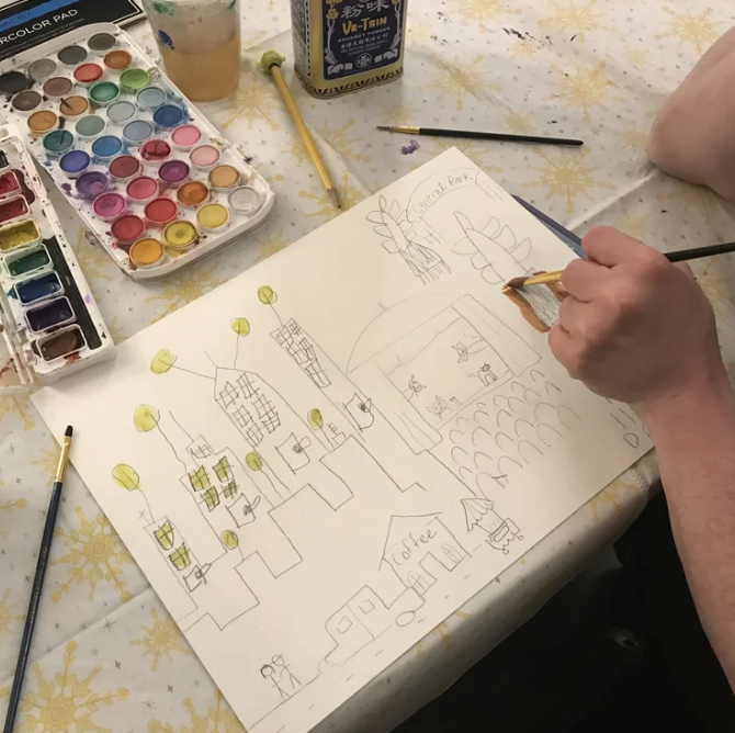 Client creating a watercolor cityscape during an art therapy session at The Sonatina Center