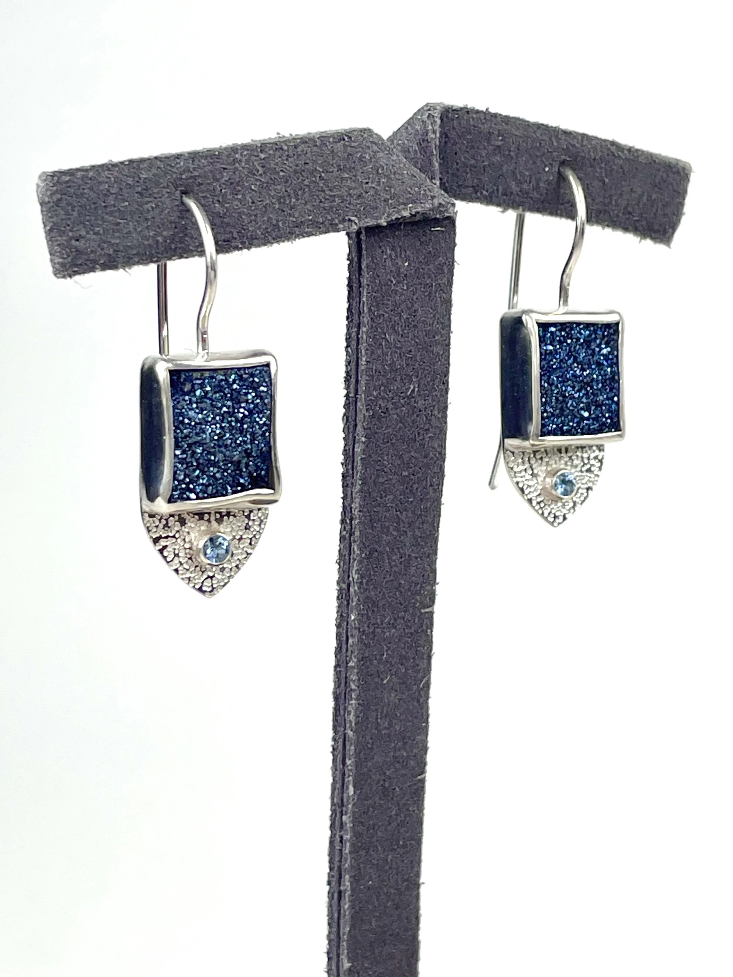 One of a kind! A pair of Brazilian blue druzy quartz stones sparkle like the stars on a cloudless summer night. AAA-grade aquamarine stones play a supporting role, tube set on a platform of textured sterling silver.