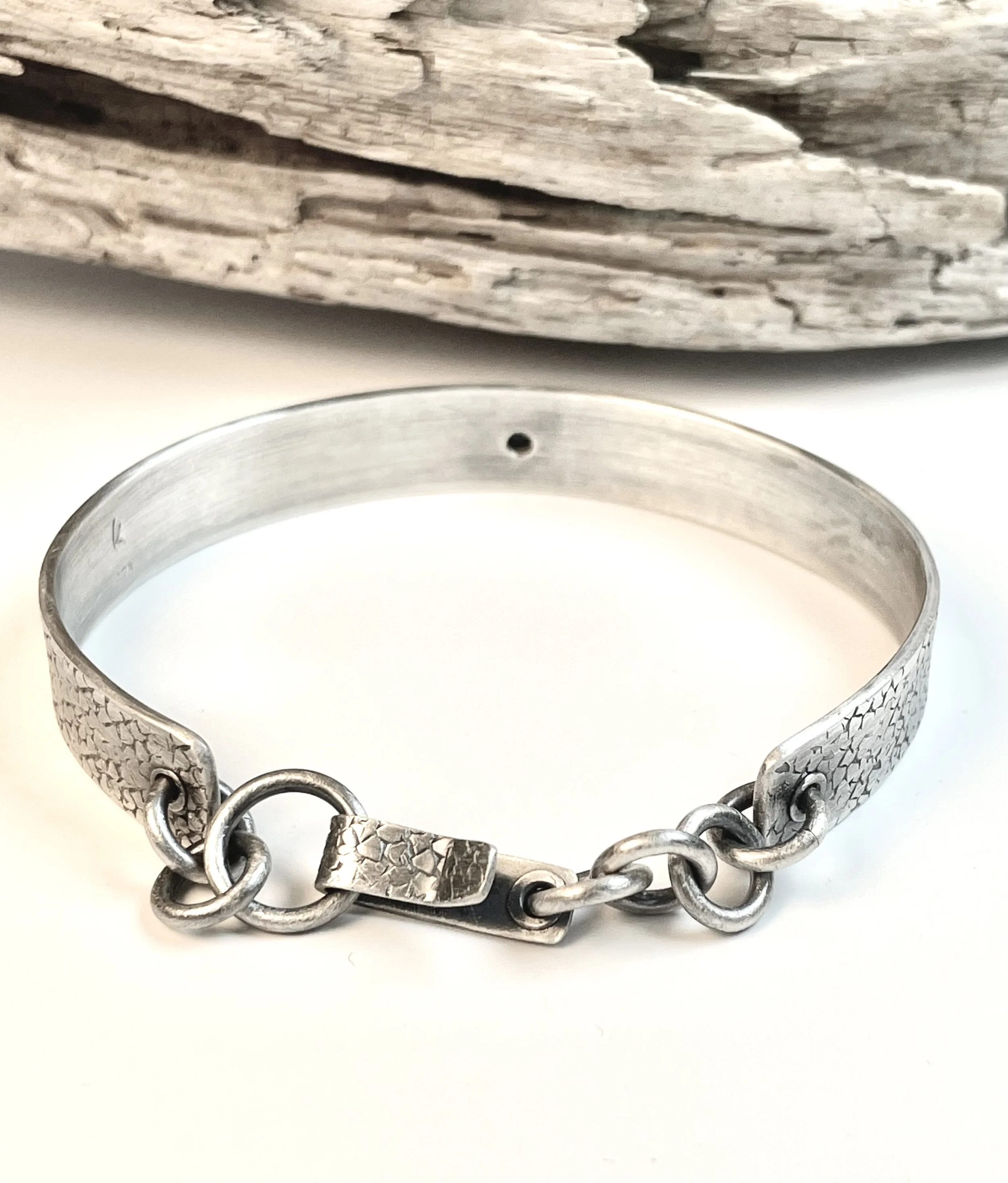 Close-up of handcrafted chain closure on handcrafted sterling silver Unbroken Cuff bracelet.