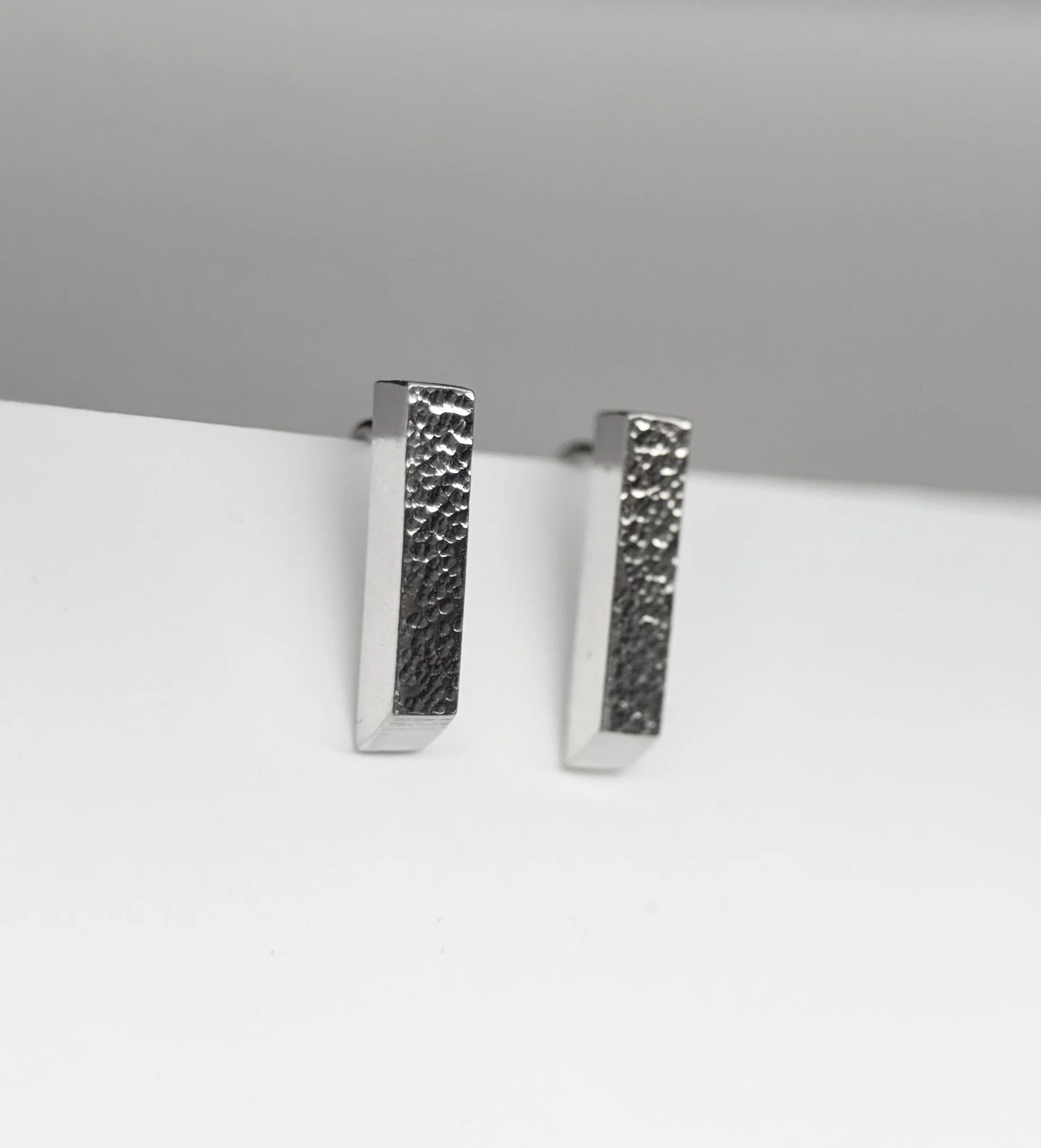 Close-up of handcrafted sterling silver Modern Stud Earrings highlighting the softly textured center and polished edges.