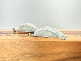 Side view of the Stormbreak Earrings featuring gray-green Saturn Jasper, textured sterling silver and bezel-set labradorite