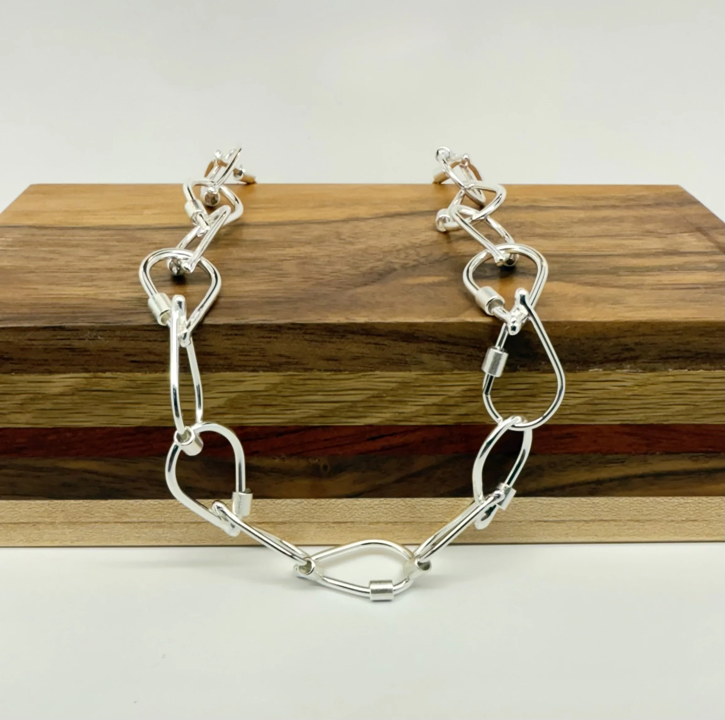 Droplet-Link-necklace-kfinndesigns-handcrafted-silver-links-on-wood-box.jpg