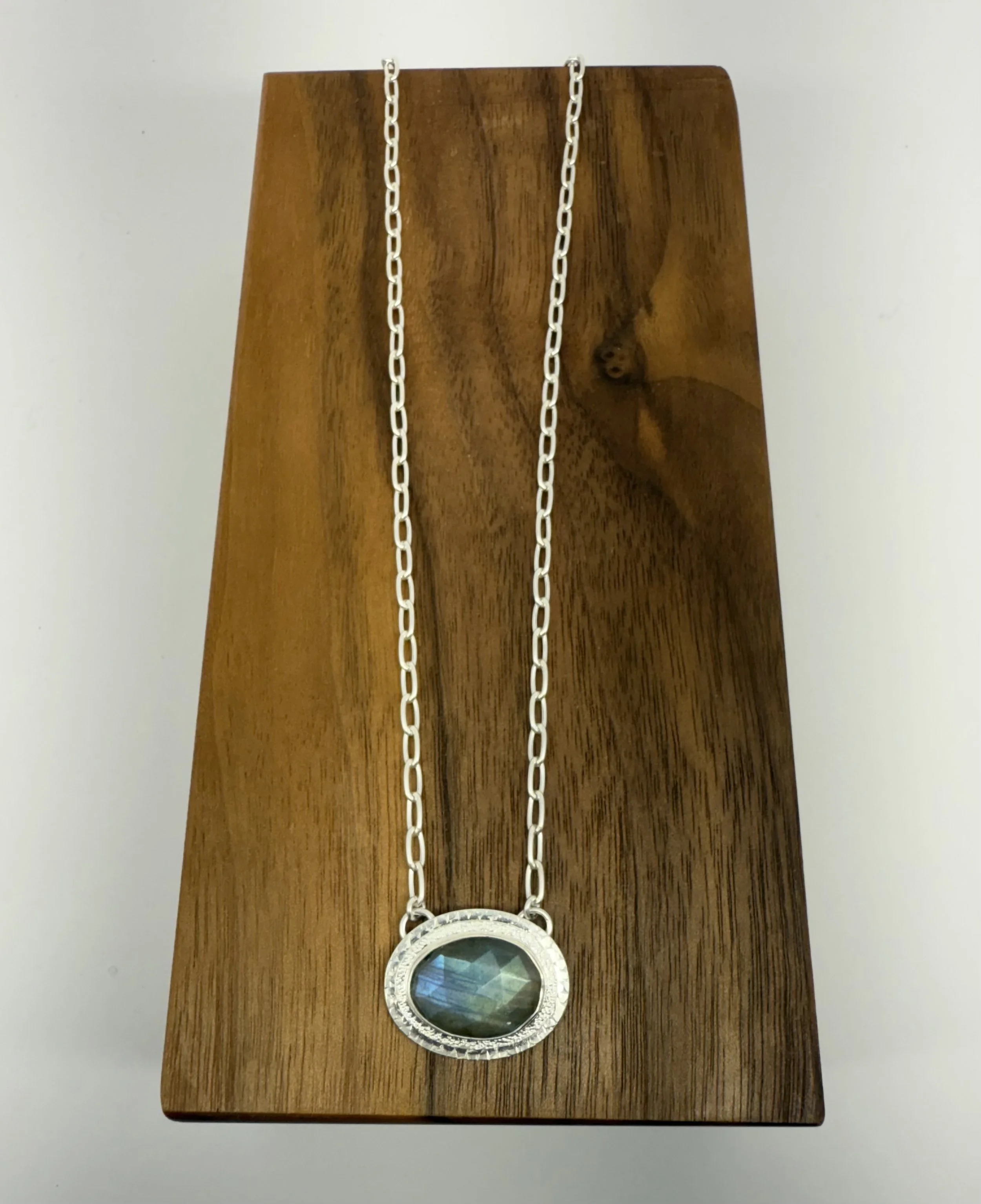 Portal Pendant Labradorite lying flat on wood.jpg