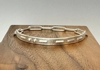 Handcrafted sterling silver Love Note Bracelet featuring hidden Morse code beads that spell "XO."