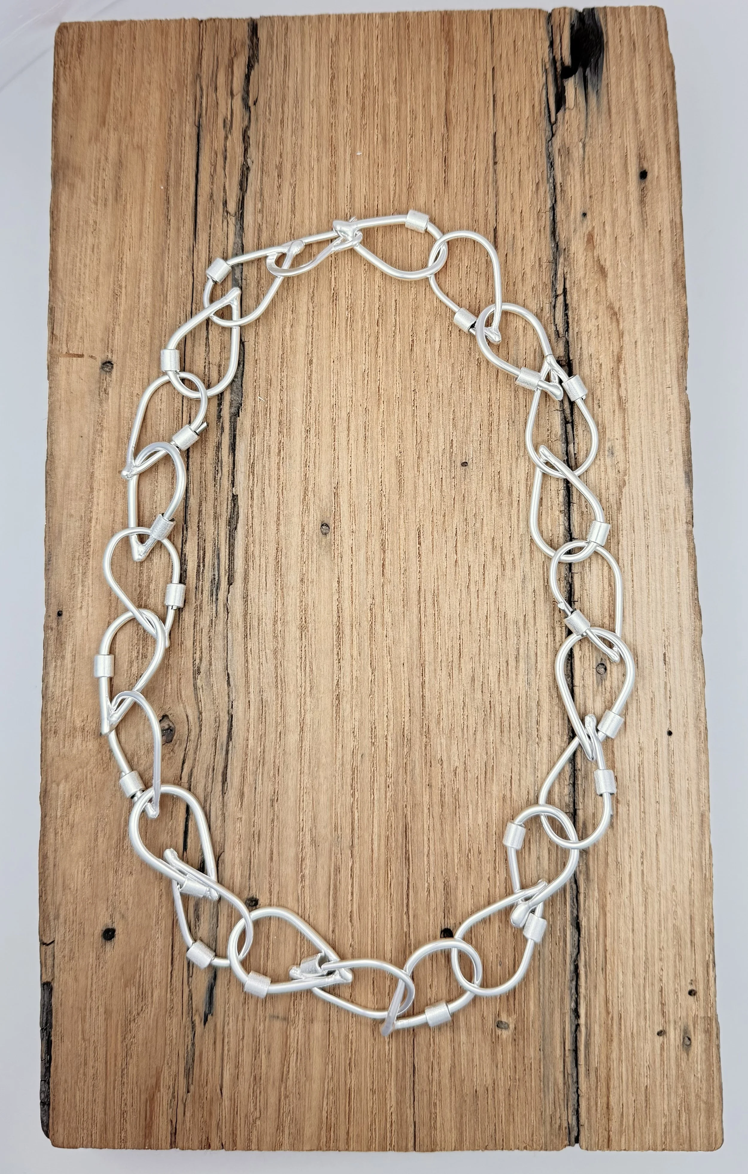 Handcrafted sterling silver Droplet Link Necklace by KFinn Designs, featuring sculptural droplet-shaped links connected in a fluid chain.